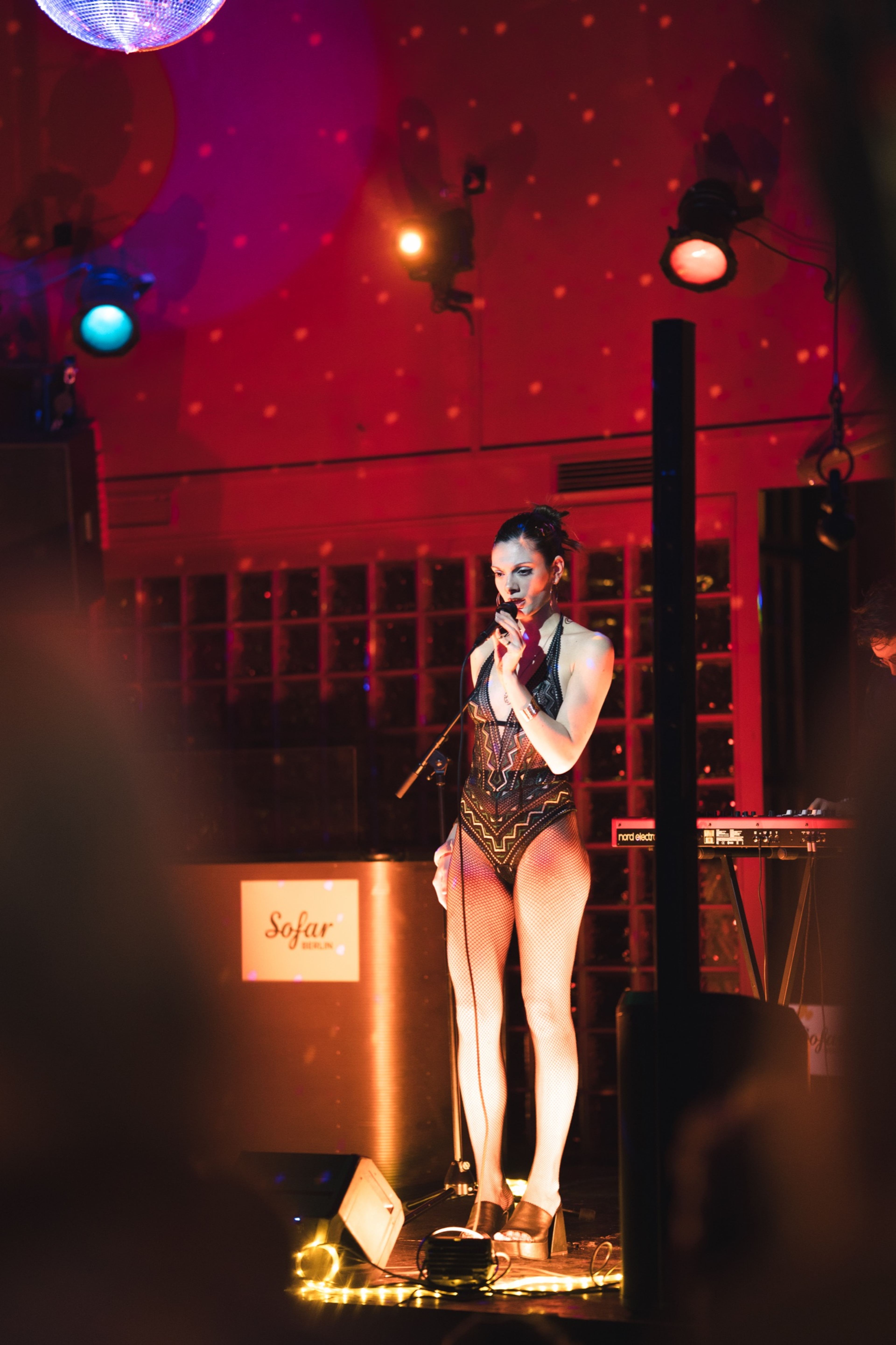 Vocalist performing under red light on the Sofar Sounds stage in Berlin