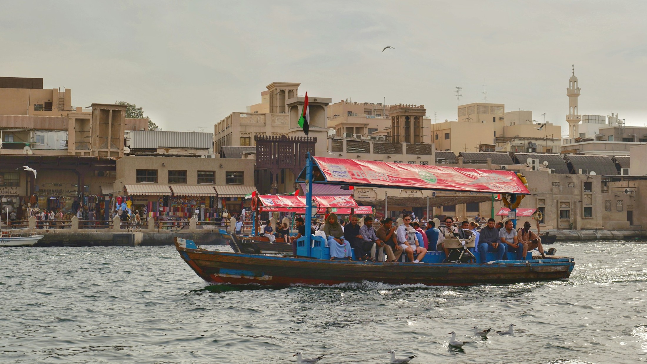 An abra crossing Dubai Creek in front of the old souks