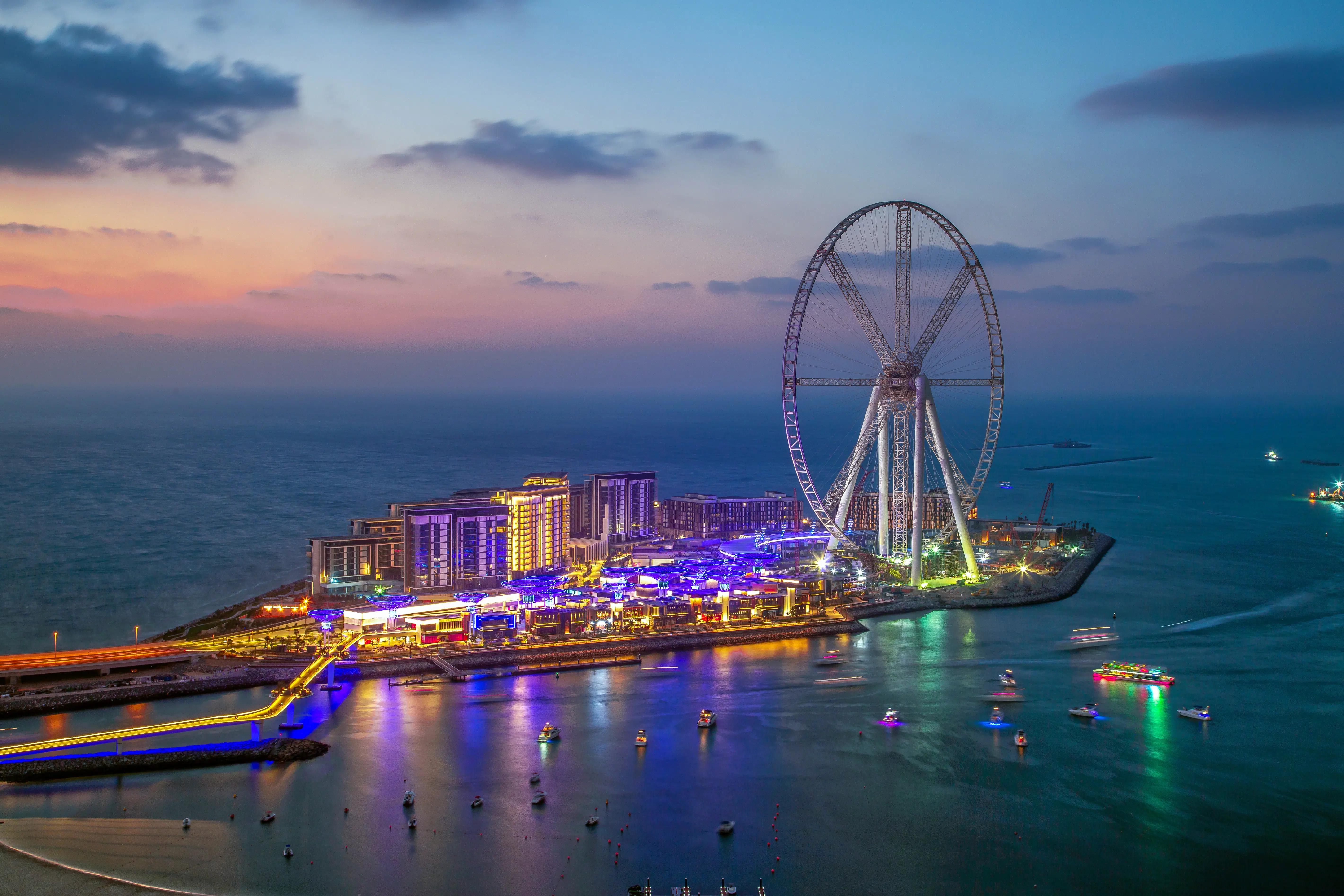 Ain Dubai and the Bluewaters waterfront lit up under a pink evening sky