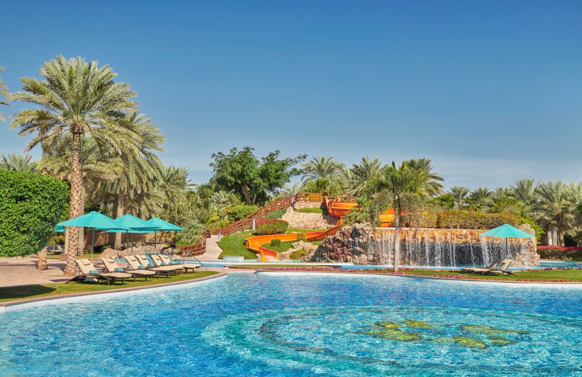 Emirates Palace pool with lazy river and water slides among palms