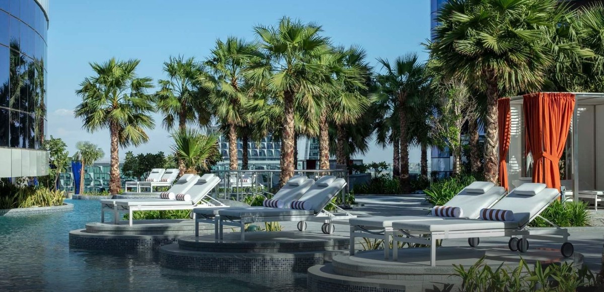 Paramount Hotel Dubai pool deck with loungers among palms