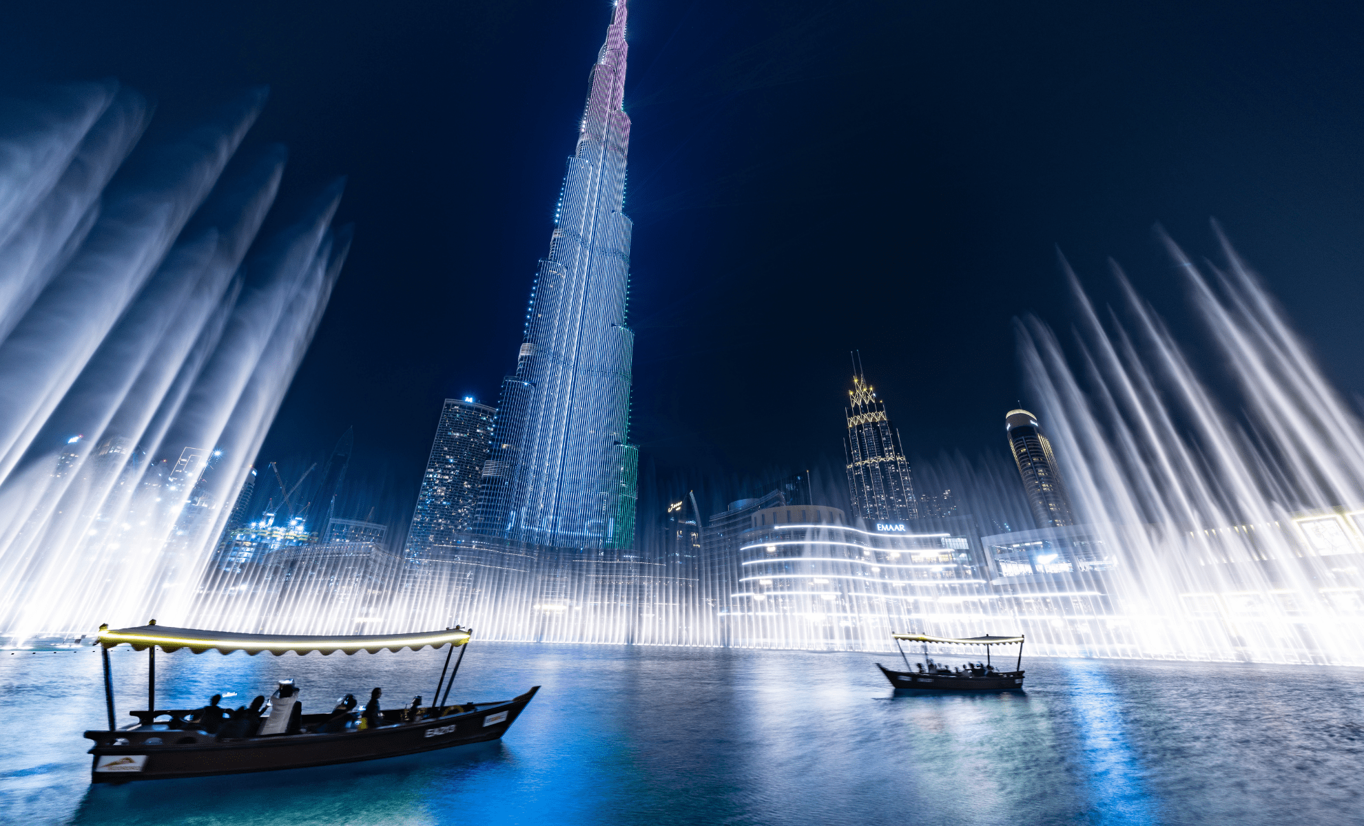 An abra on Burj Lake as the fountain jets rise in front of the Downtown towers