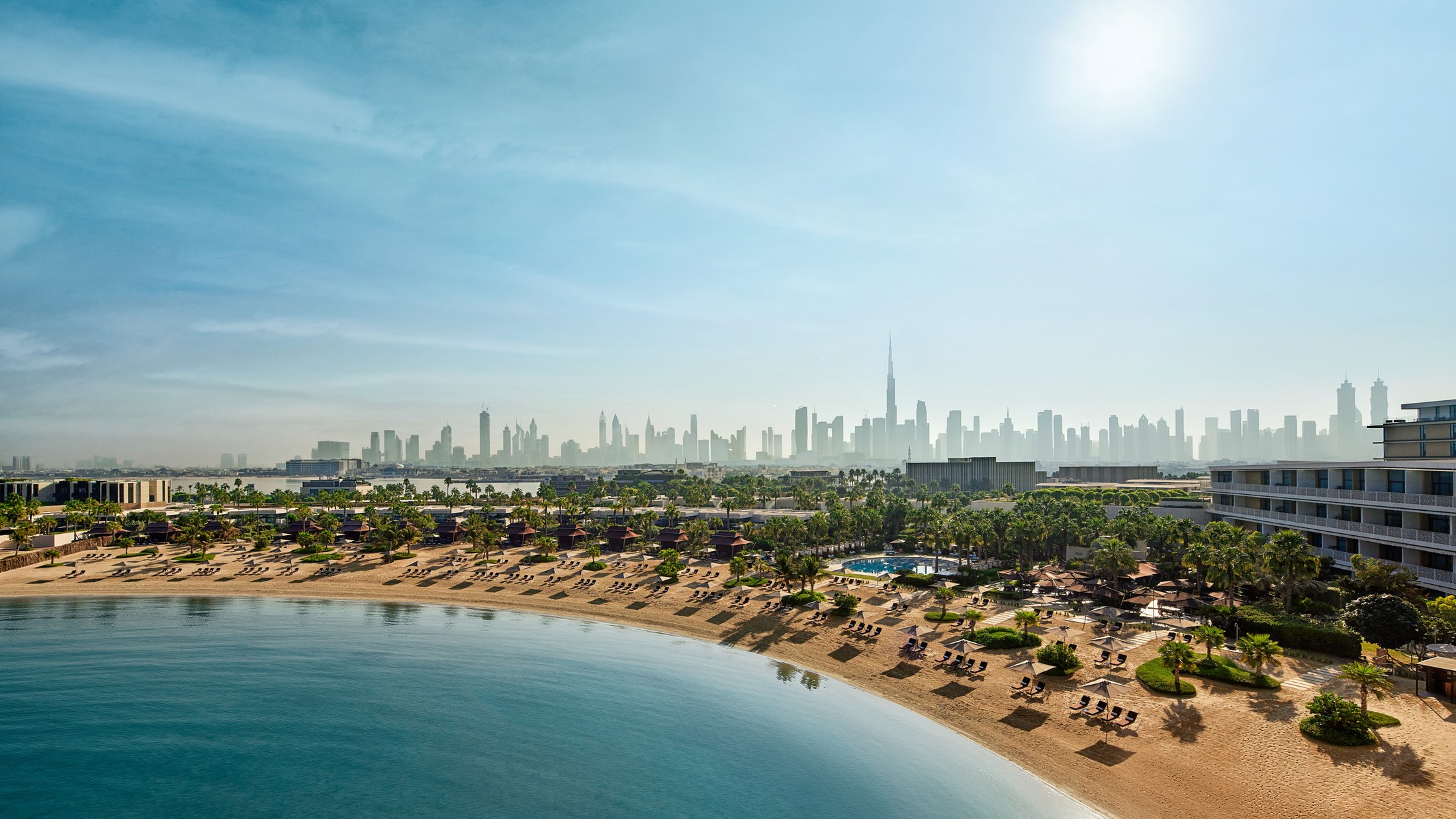 The beach at Bulgari Resort Dubai, with the city skyline beyond
