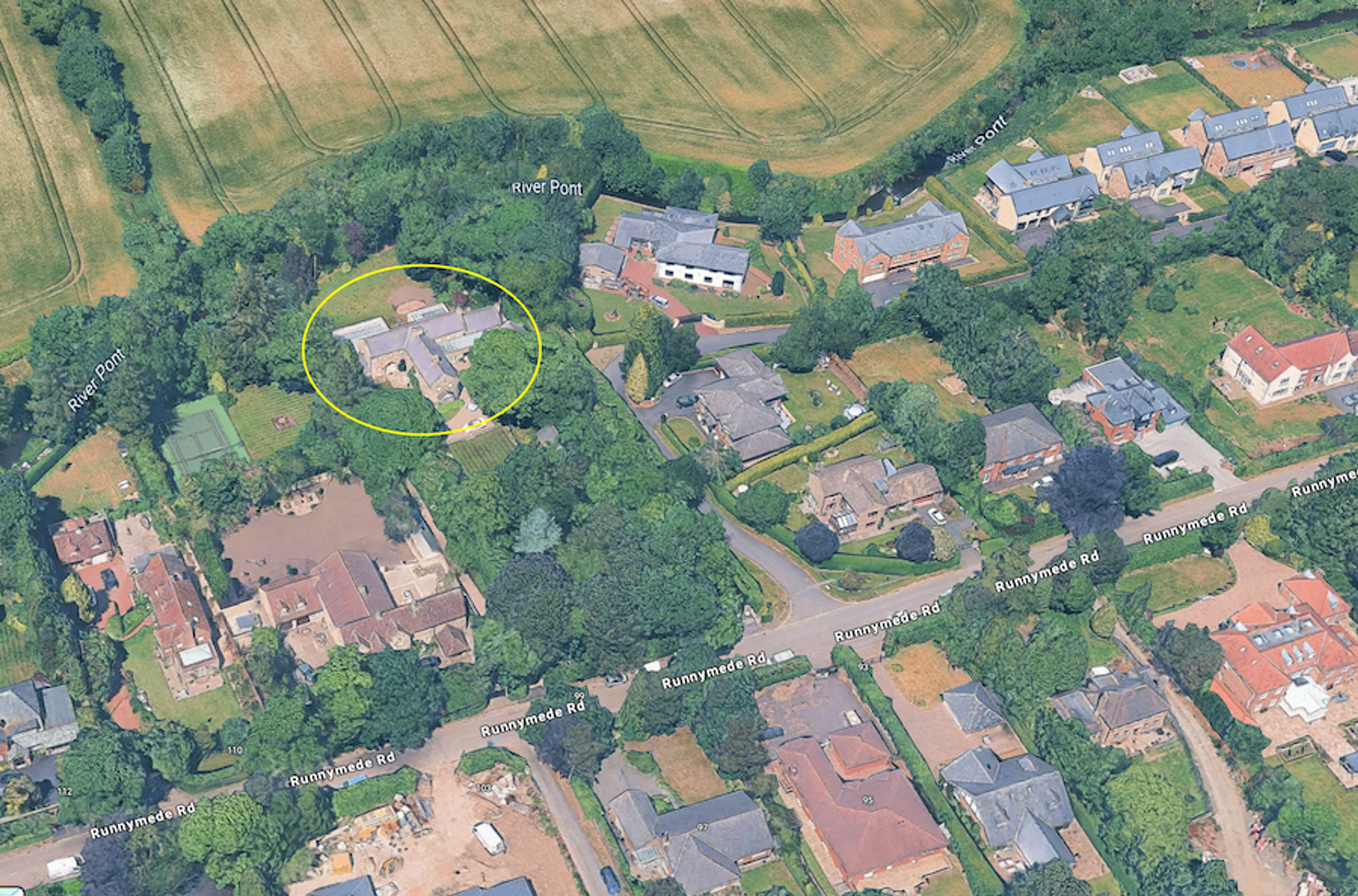 Aerial view of houses beside the River Pont, with a yellow ellipse marking a building among the trees