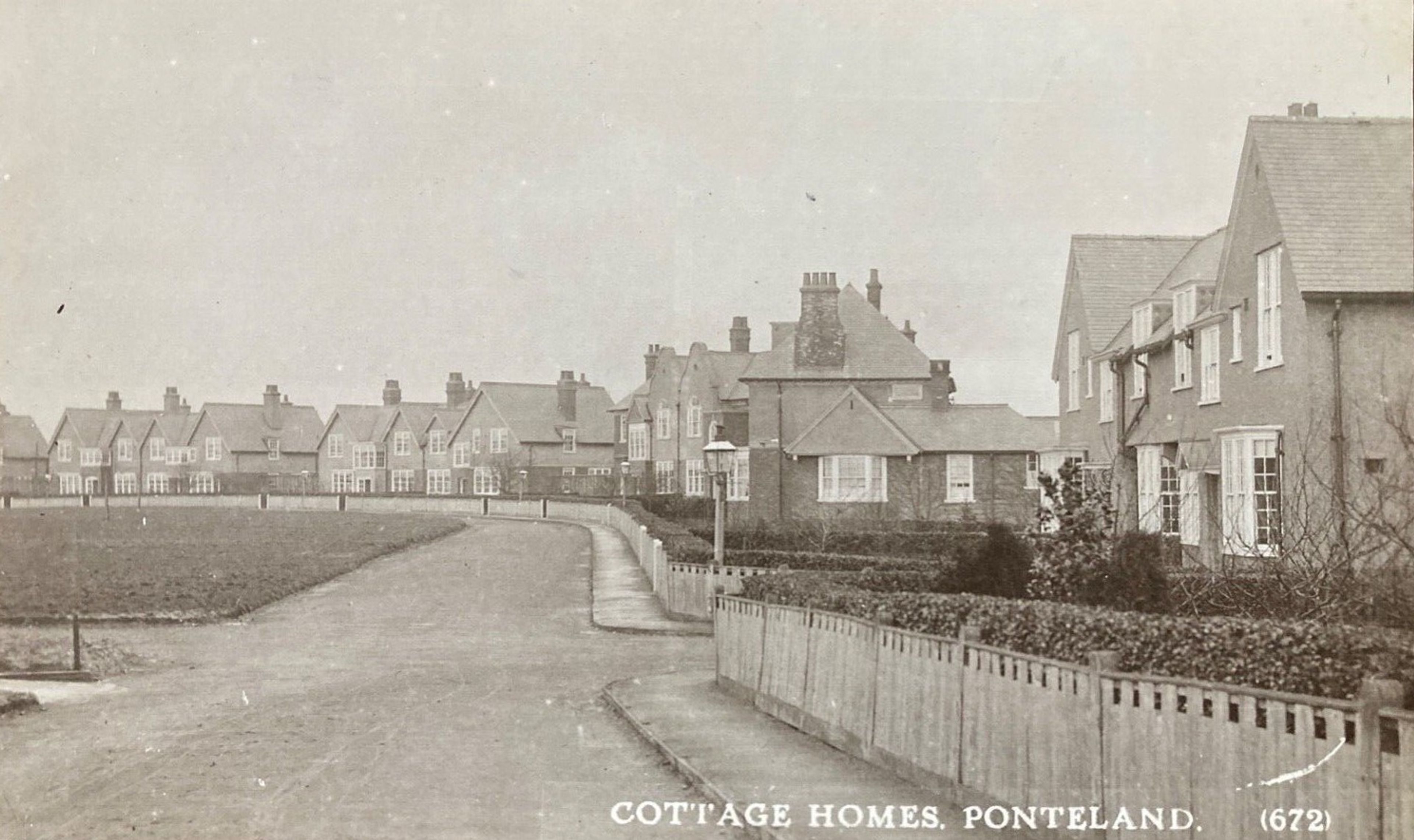 Sepia postcard of a wide street lined with gabled cottages, captioned Cottage Homes, Ponteland