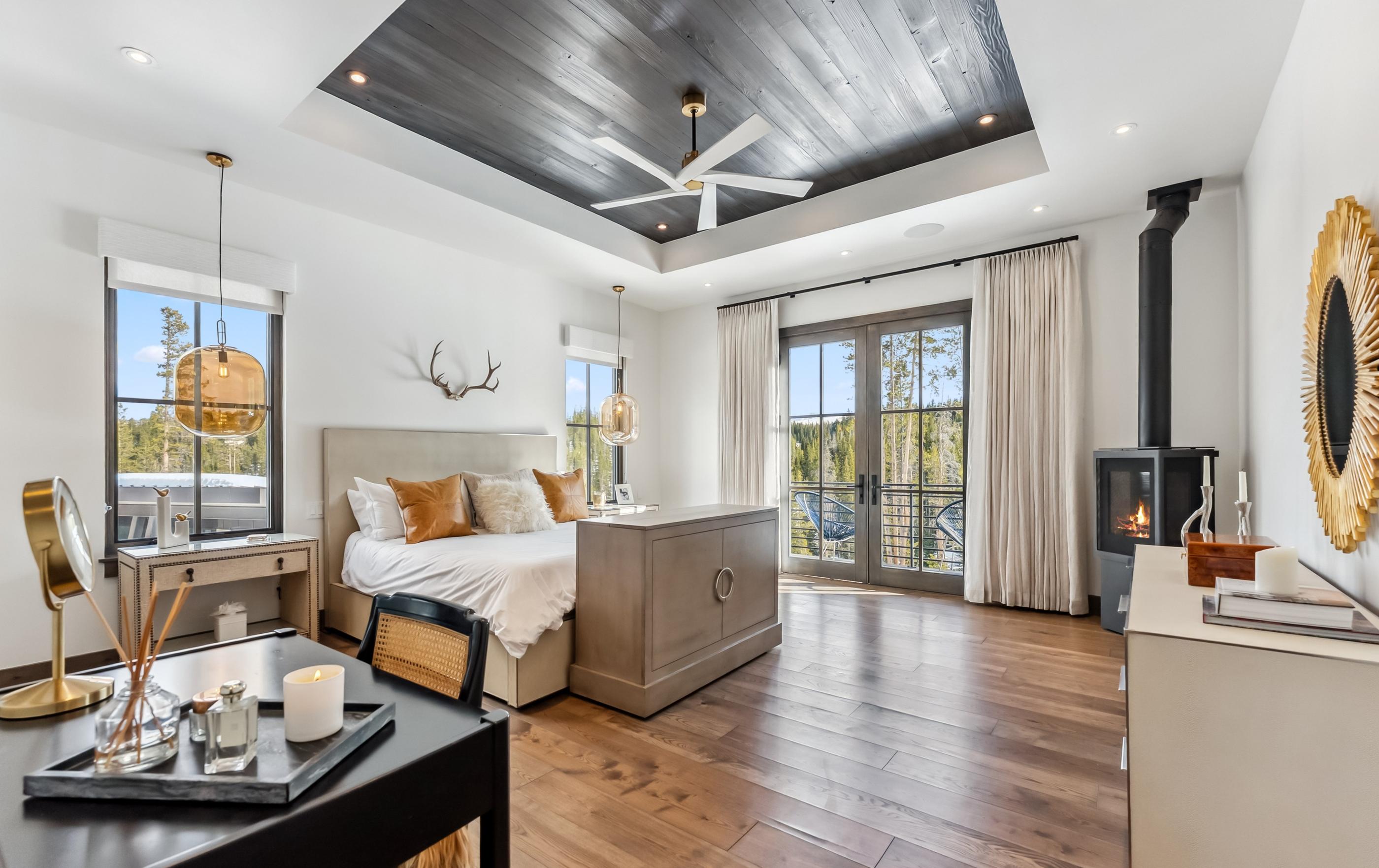 Bedroom of an Iron Forest home, with a wood stove and doors onto the trees