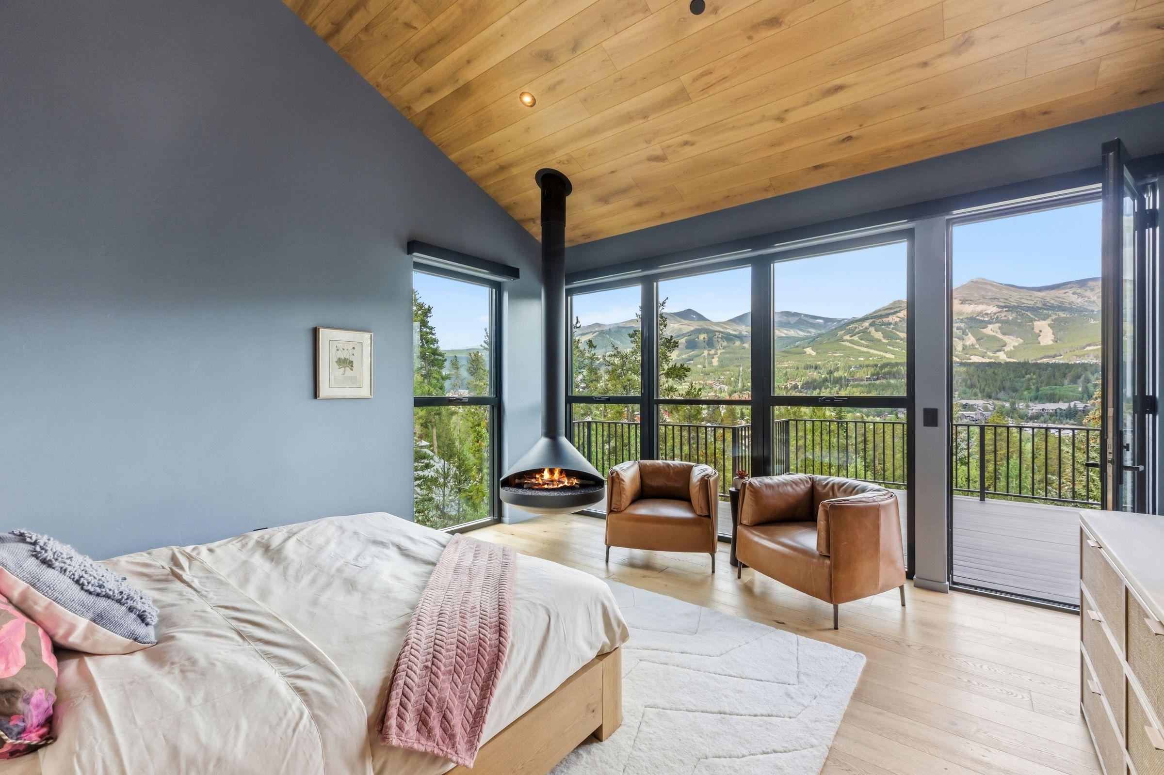 Bedroom opening to a wall of windows onto the mountains
