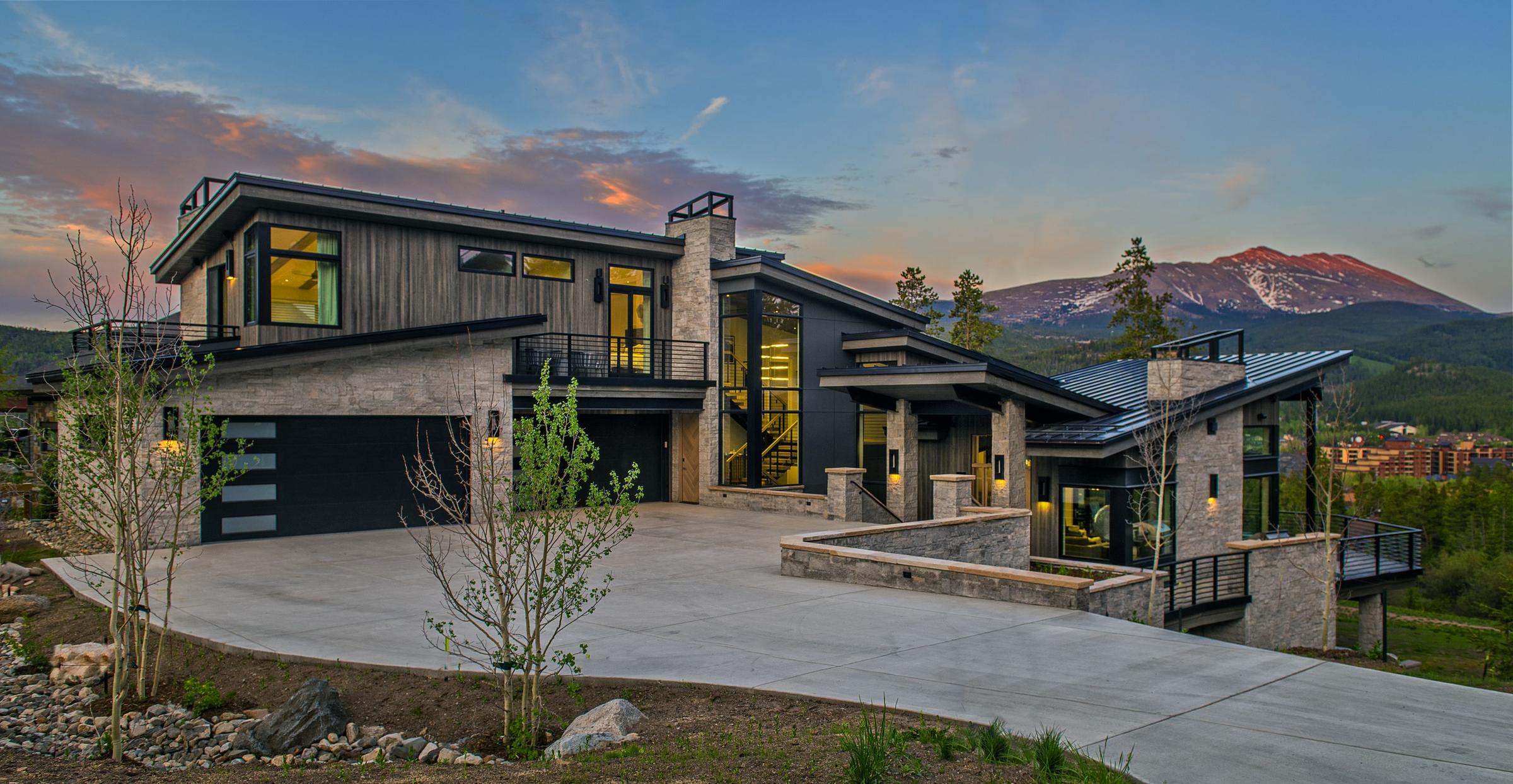 The Beavers residence at dusk, its windows lit against the ridgeline behind