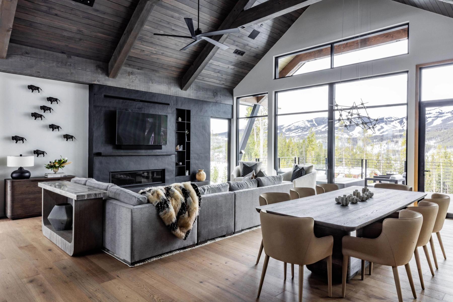 Great room of the Highlands residence under a timber ceiling, dining beyond and windows onto the range