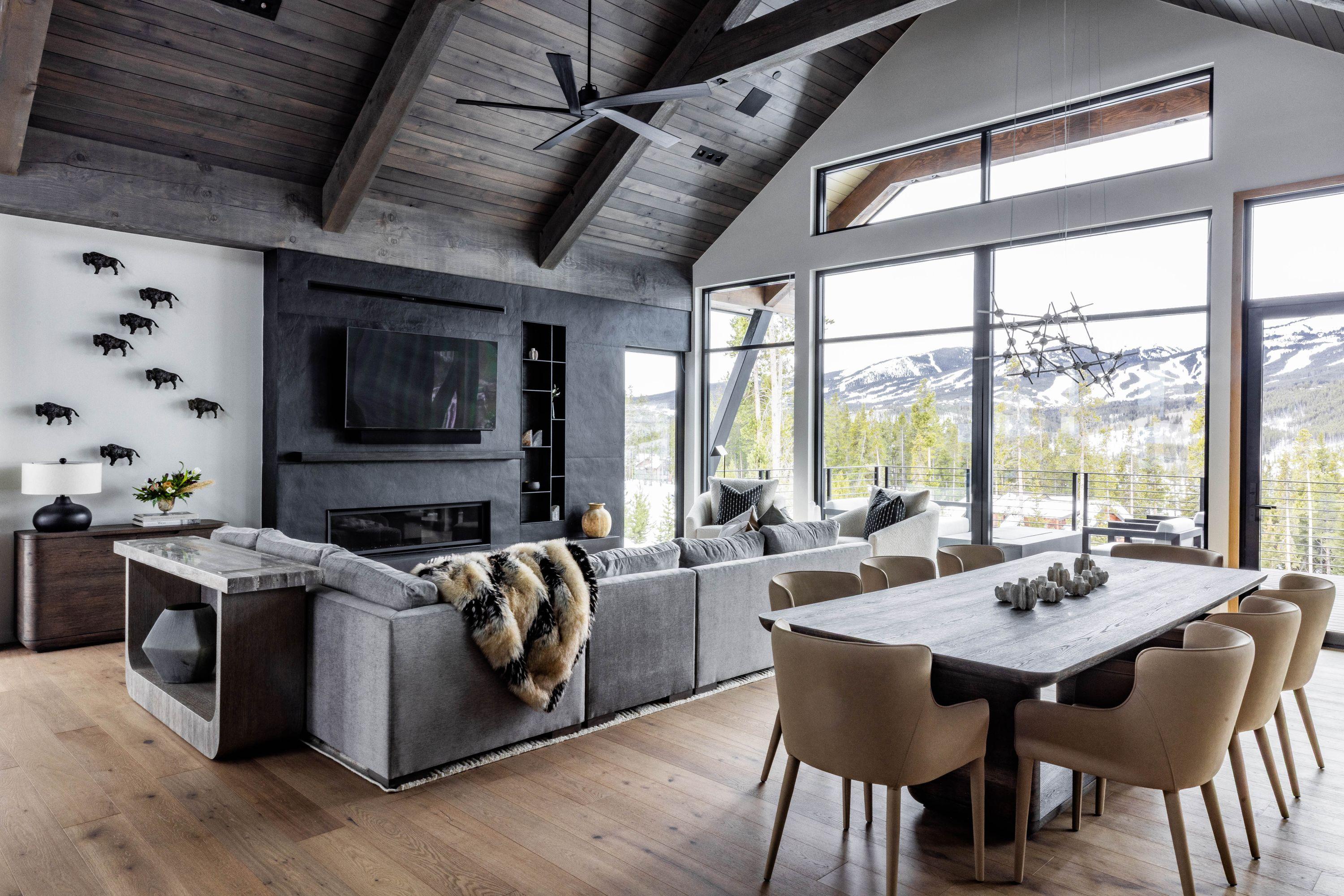 Great room of the Highlands residence under a timber ceiling, dining beyond and windows onto the range