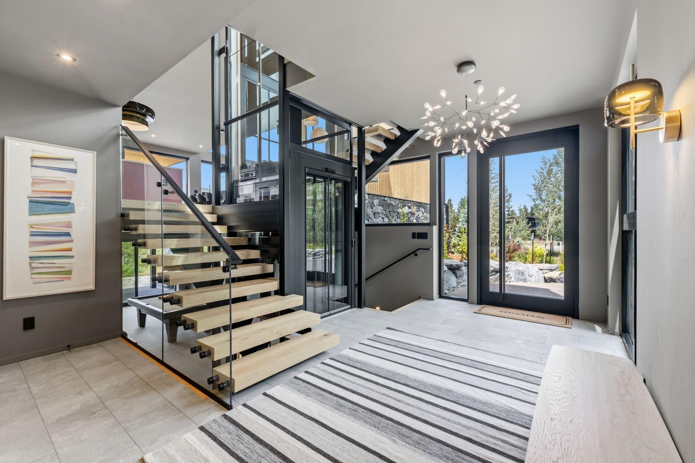 Stair hall around the glass elevator, chandelier overhead