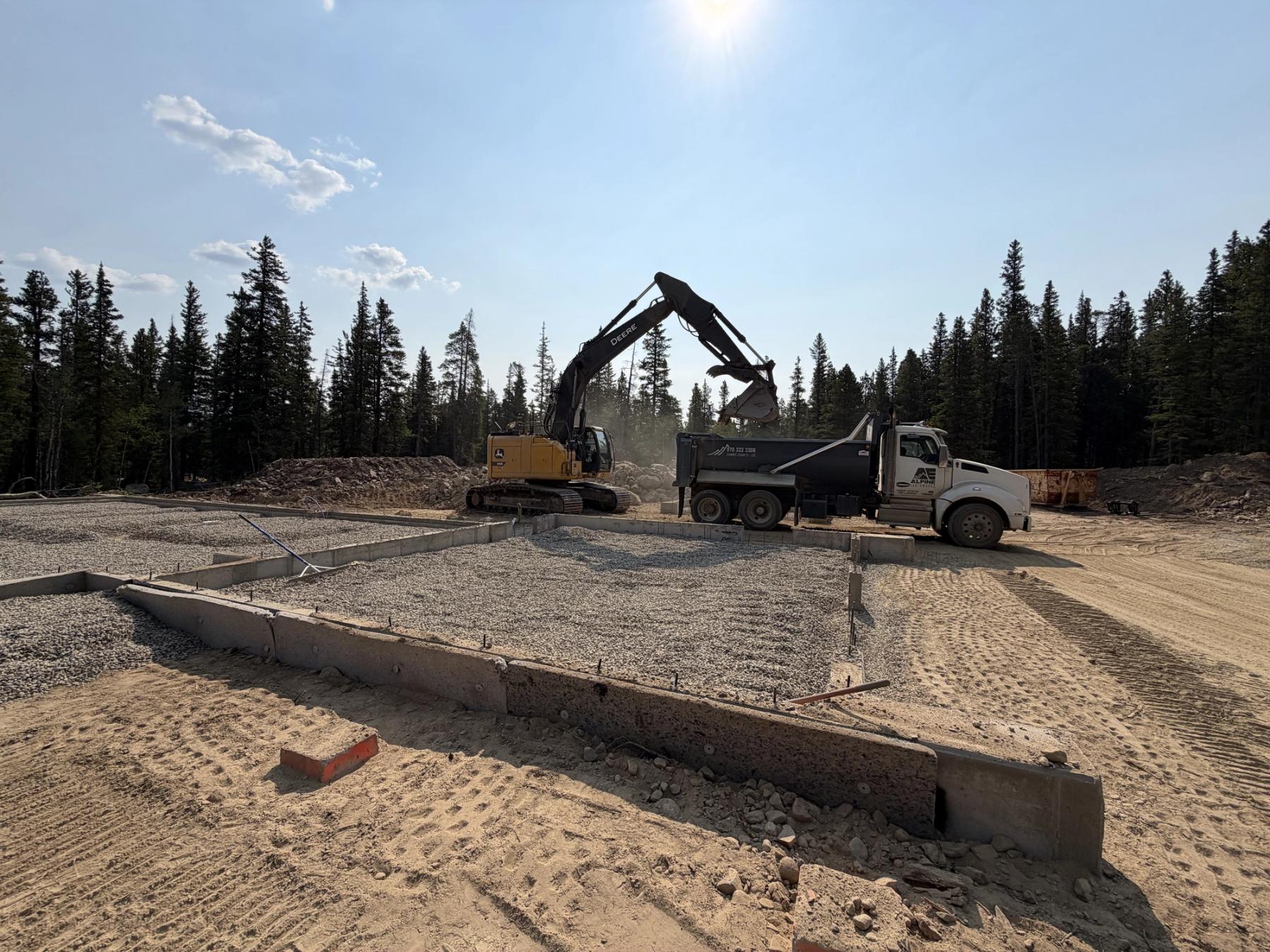 Excavator preparing a mountain homesite at the start of construction