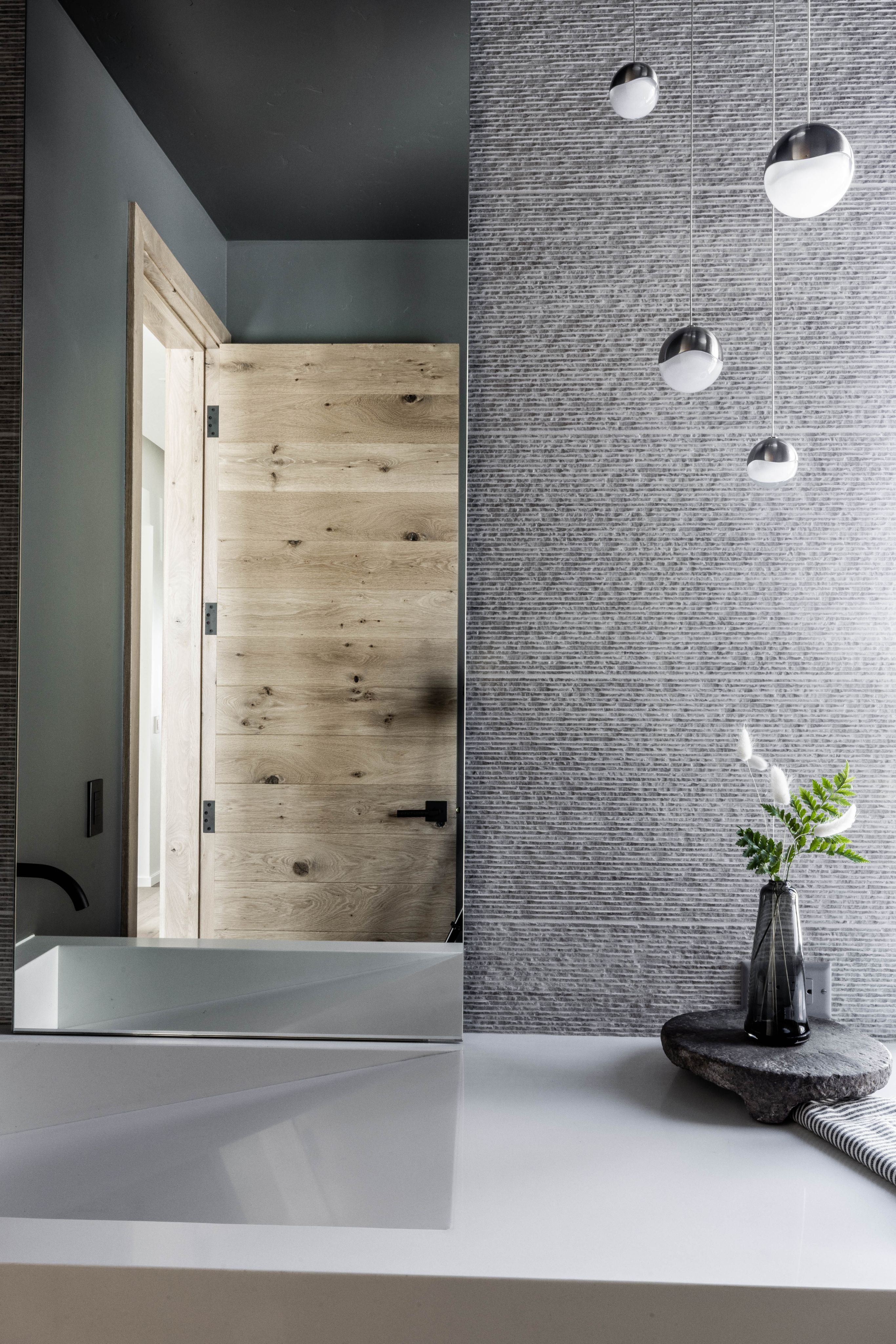 Remodeled interior entry with dark stone wall and warm wood detailing