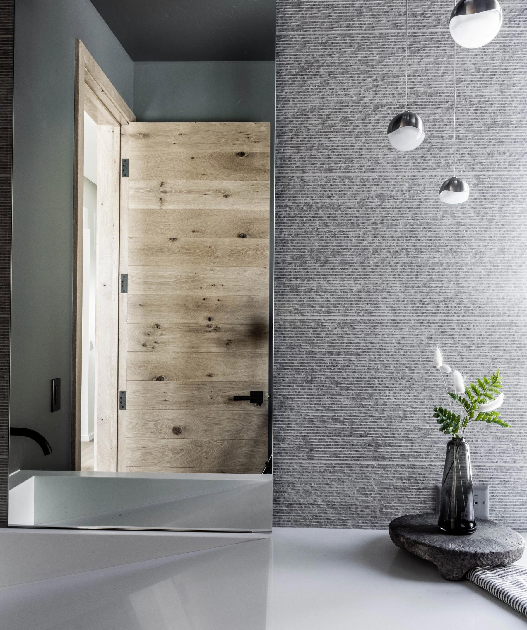 Remodeled interior entry with dark stone wall and warm wood detailing