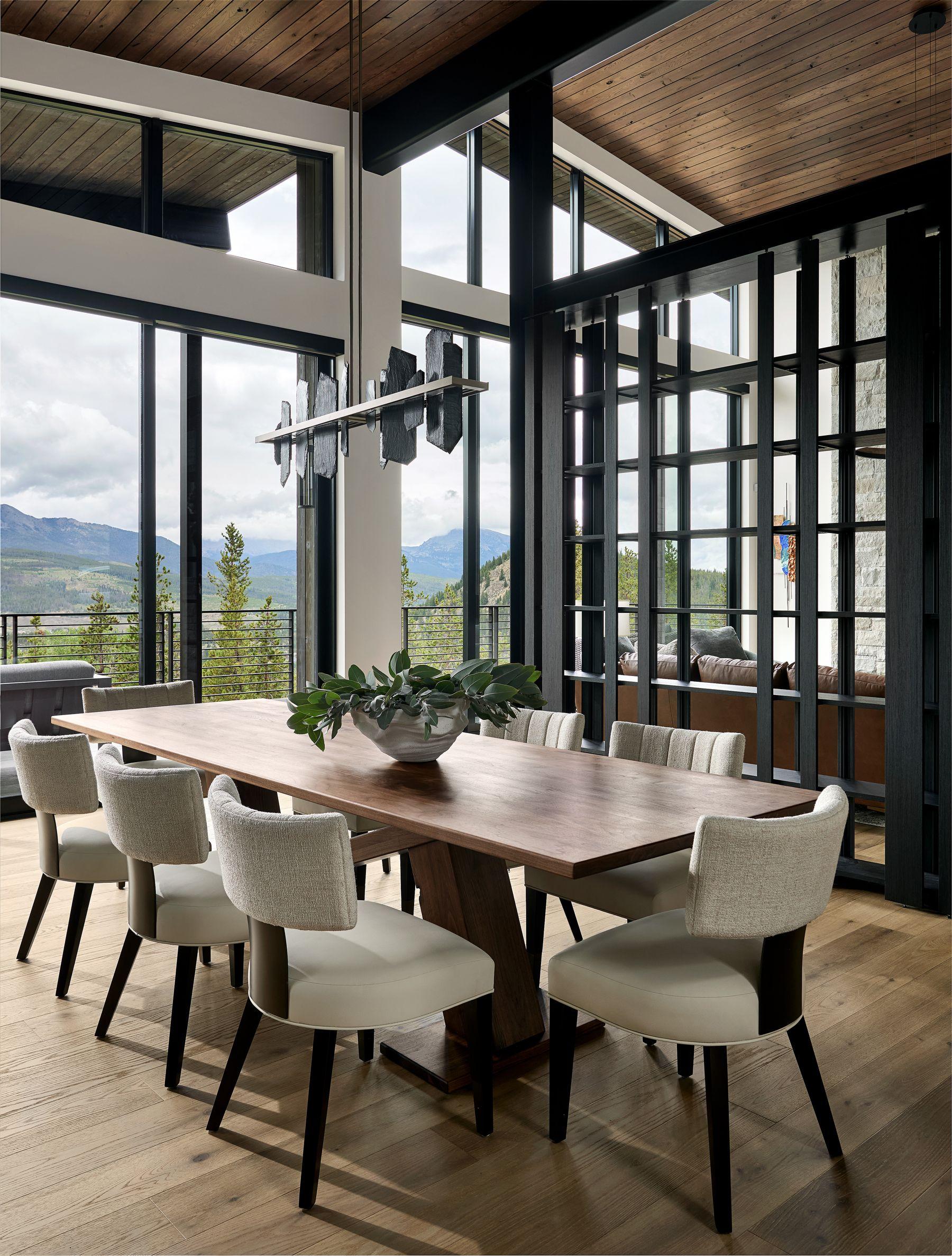 Dining table set the length of the window wall, mountains beyond
