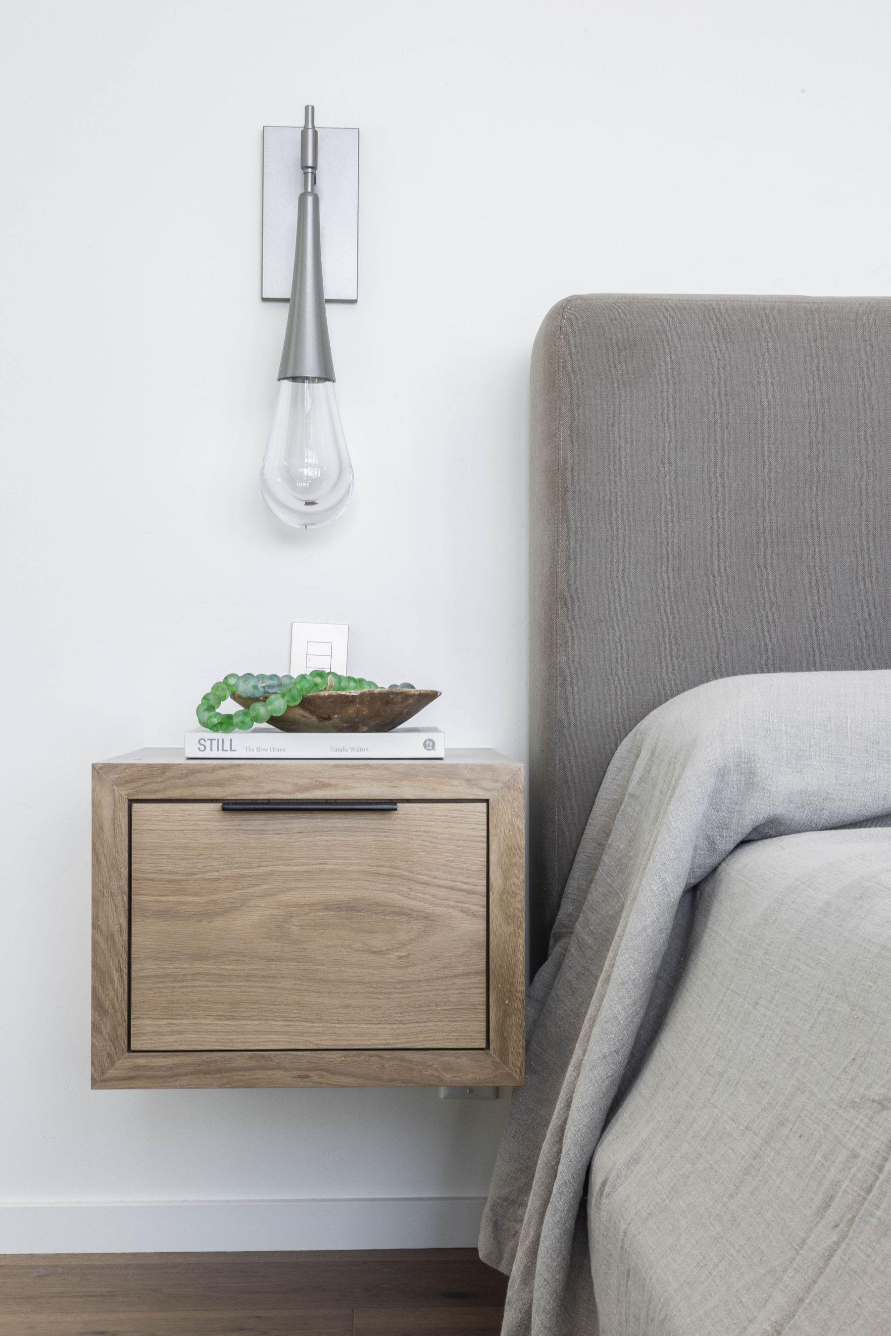 Bedroom with an upholstered headboard and a wall sconce