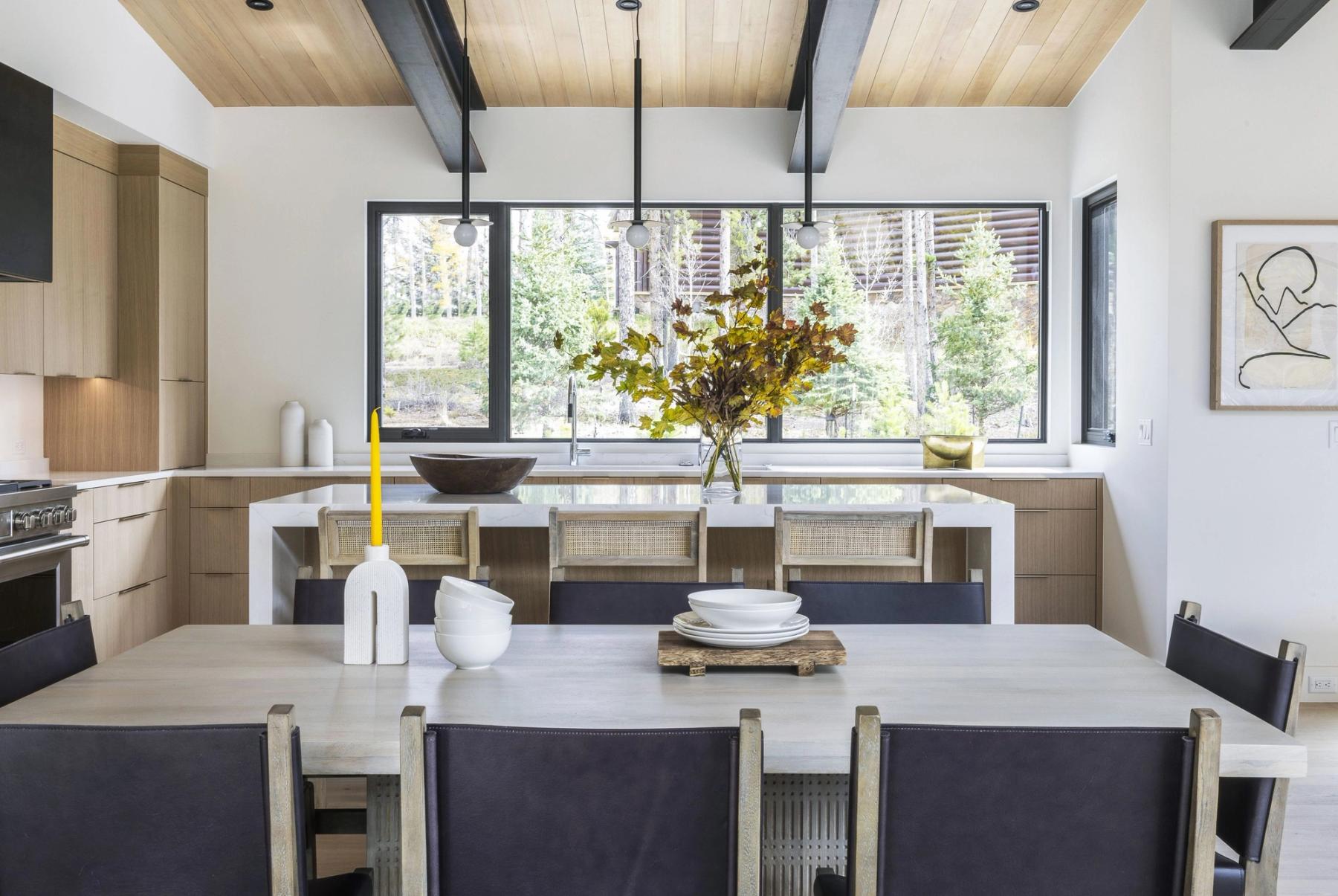 Dining room of the Windflower residence, black chairs beneath a sculptural pendant