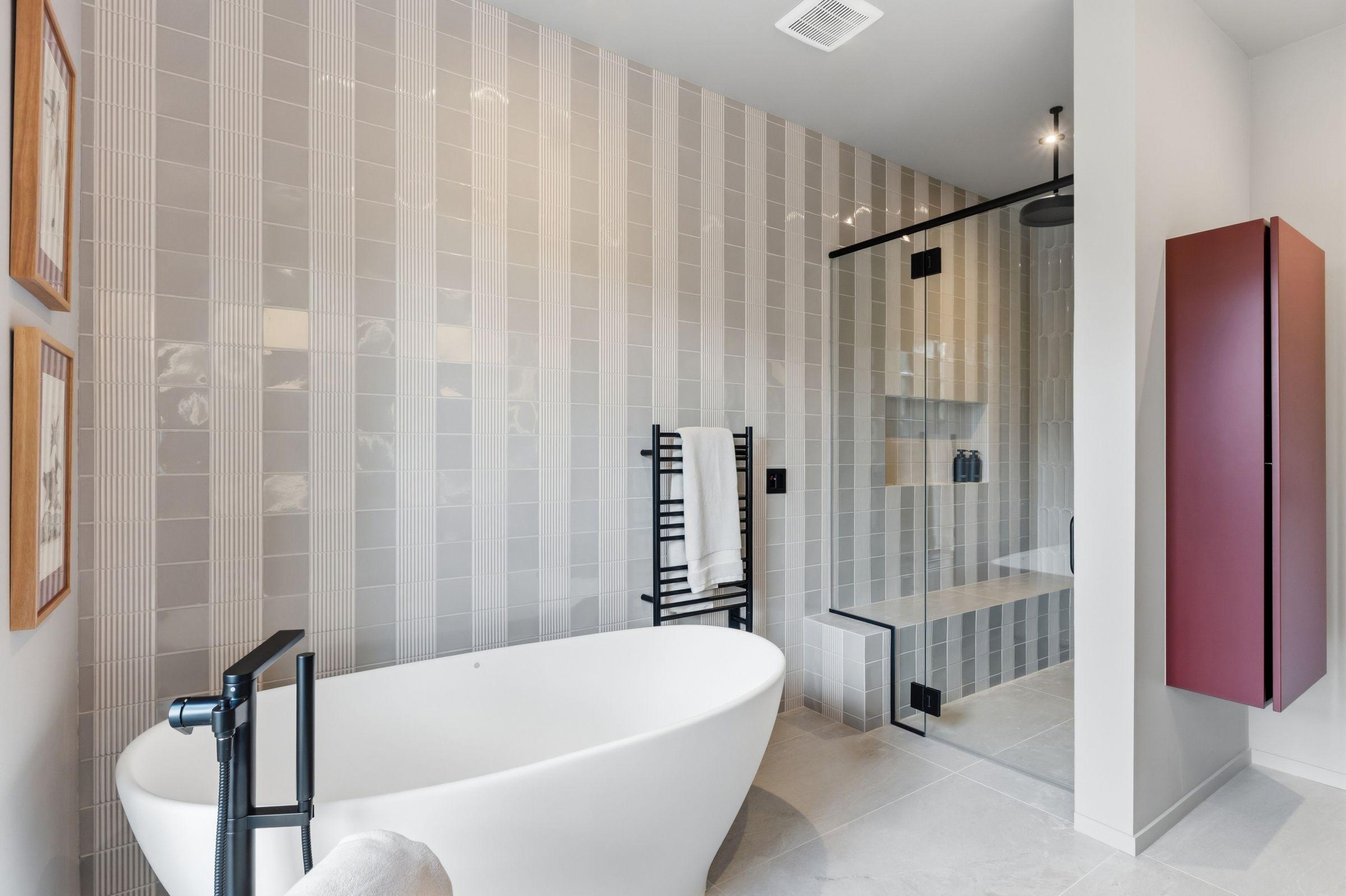 Bathroom with a freestanding tub against a striped wall