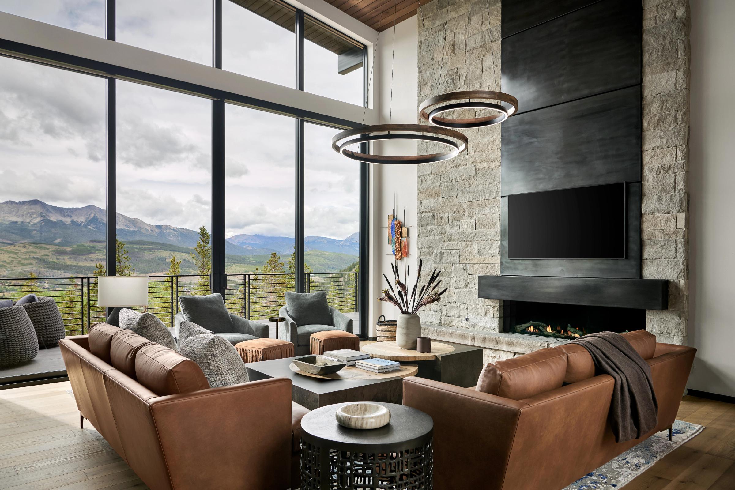 Great room of a custom Iron Forest mountain home, with leather seating and floor-to-ceiling windows facing the Tenmile Range