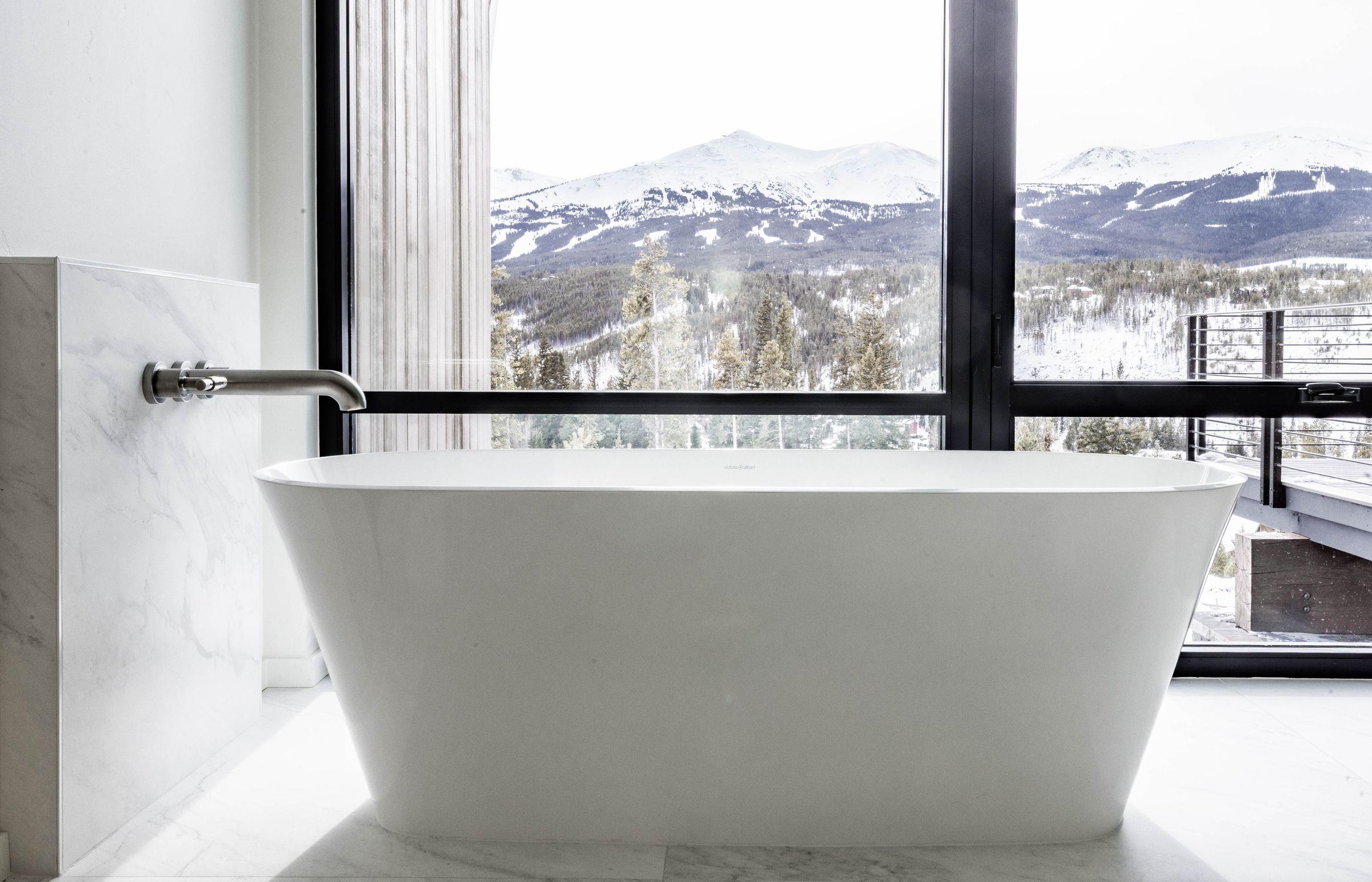 Freestanding tub set to a window onto the mountains