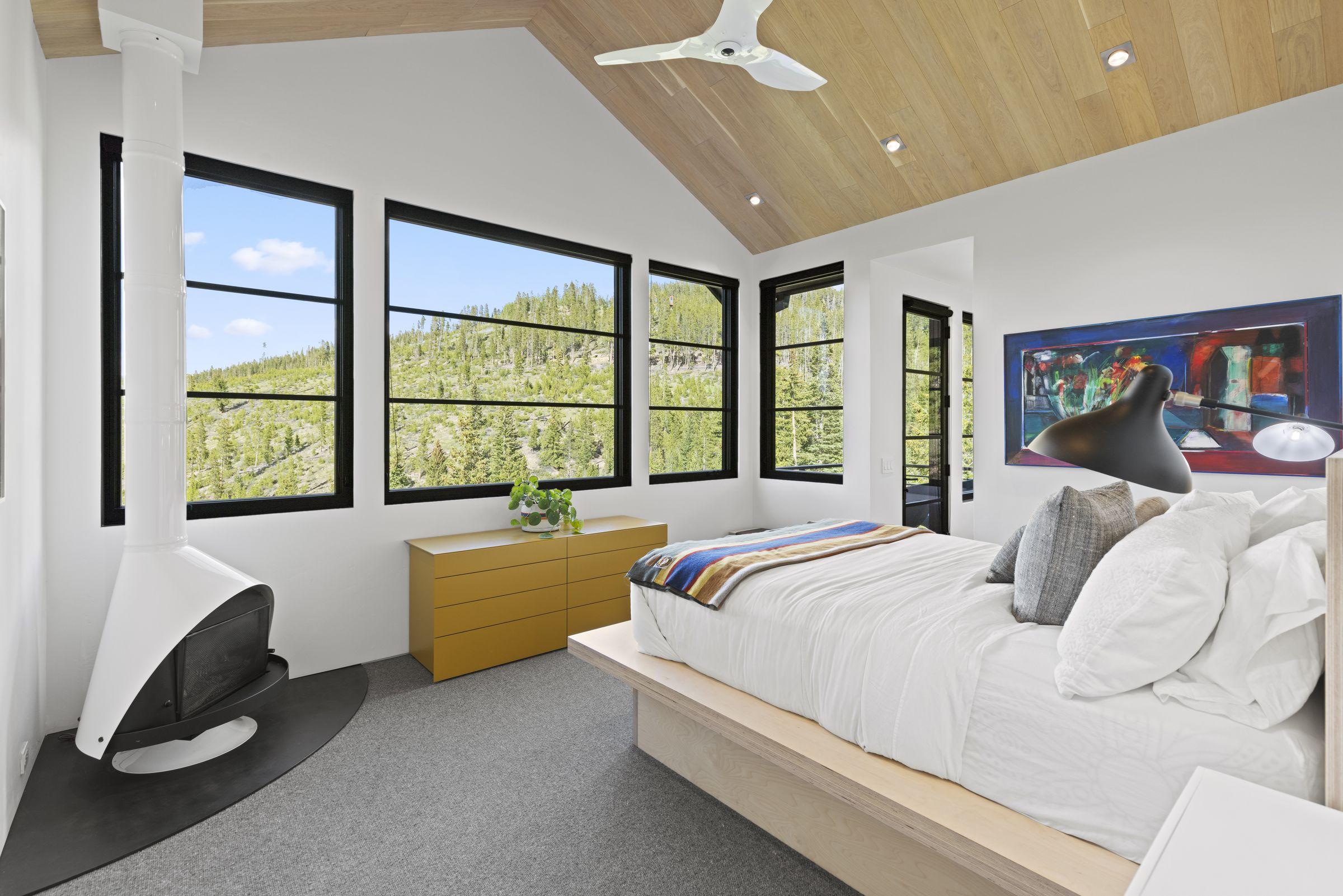 Bedroom in white with windows framing the pines, Disco Scandi residence
