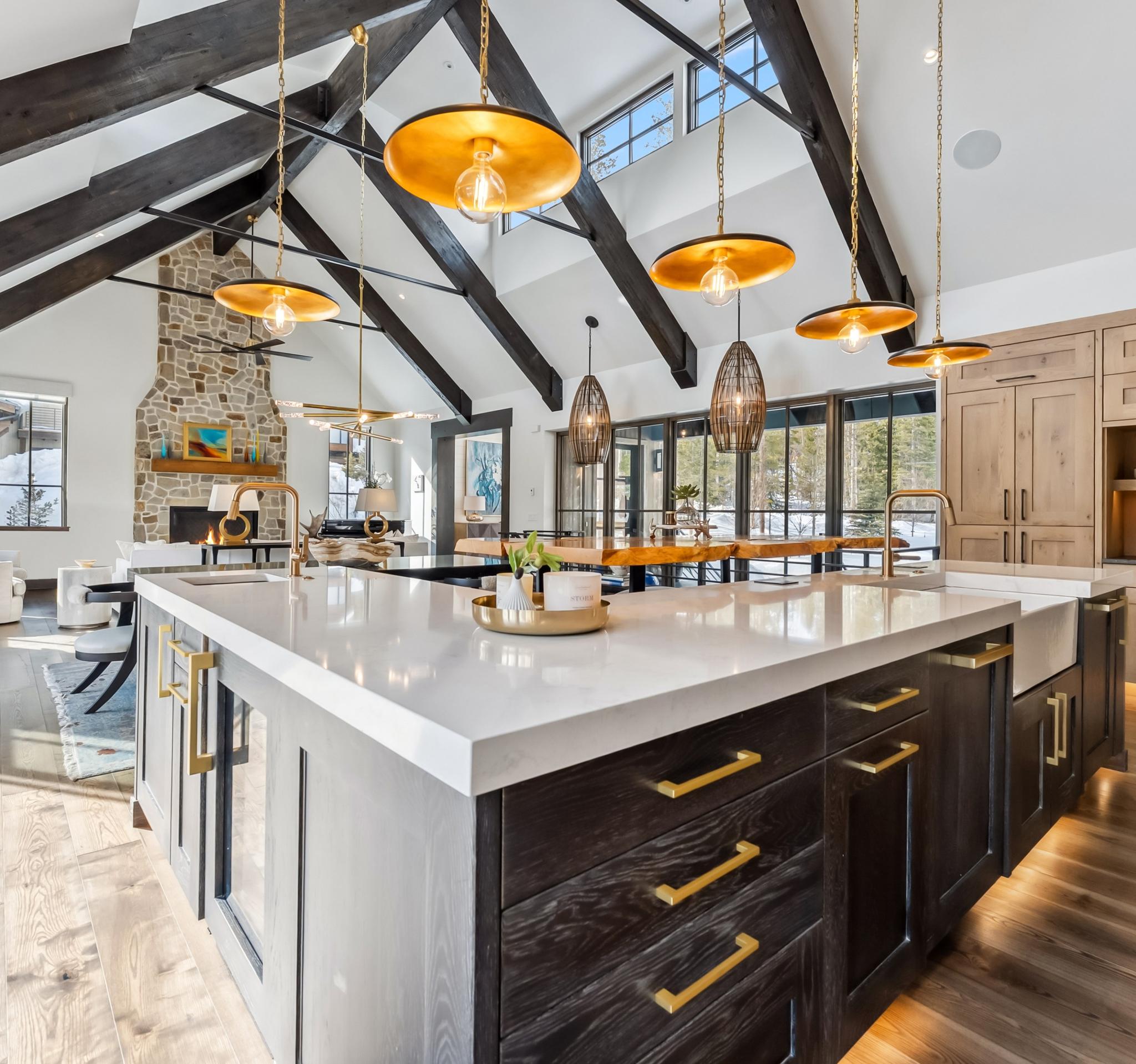 Kitchen and great room of an Iron Forest home, under exposed timber trusses