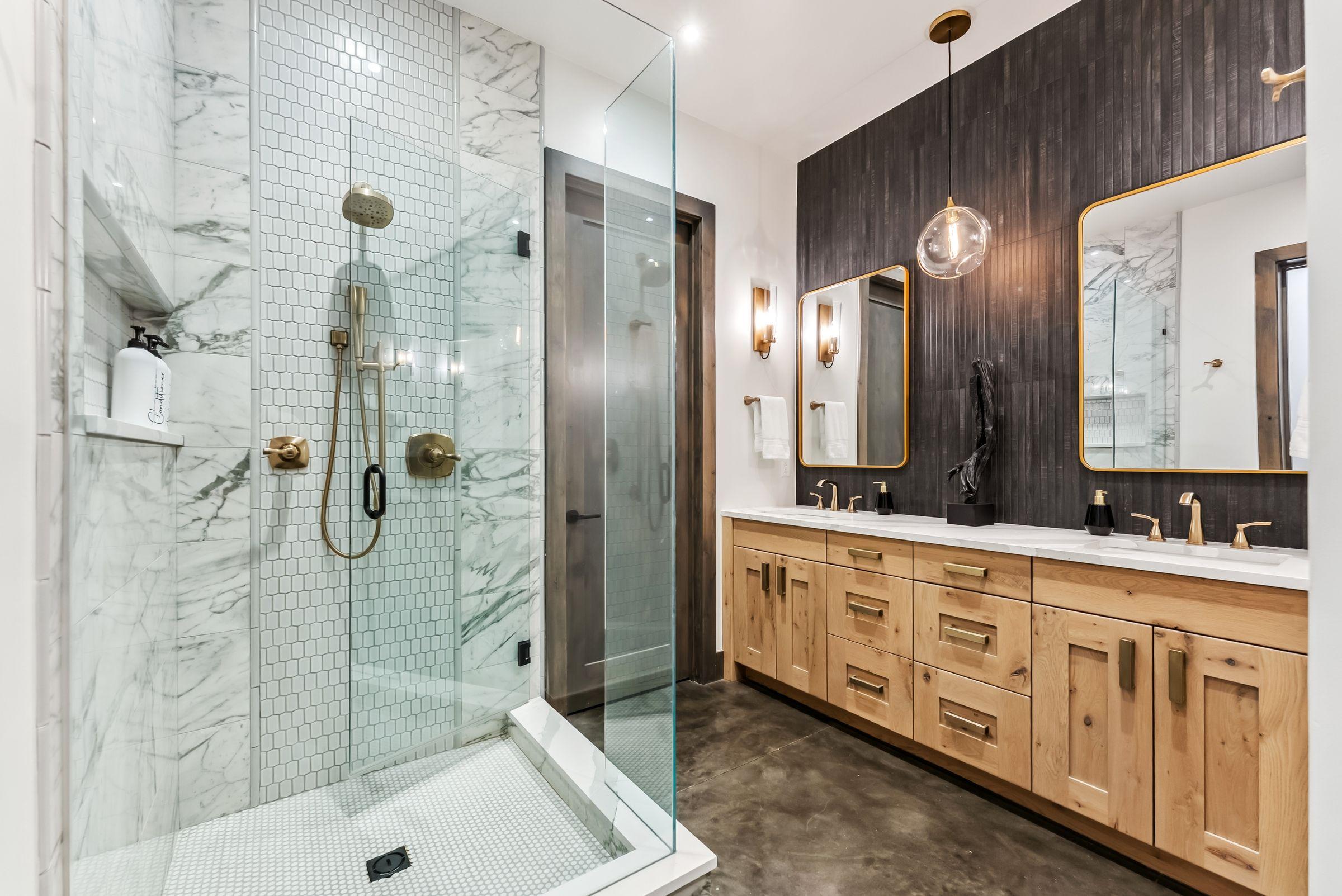 Primary bathroom with a glass shower, double vanity and pale timber cabinetry