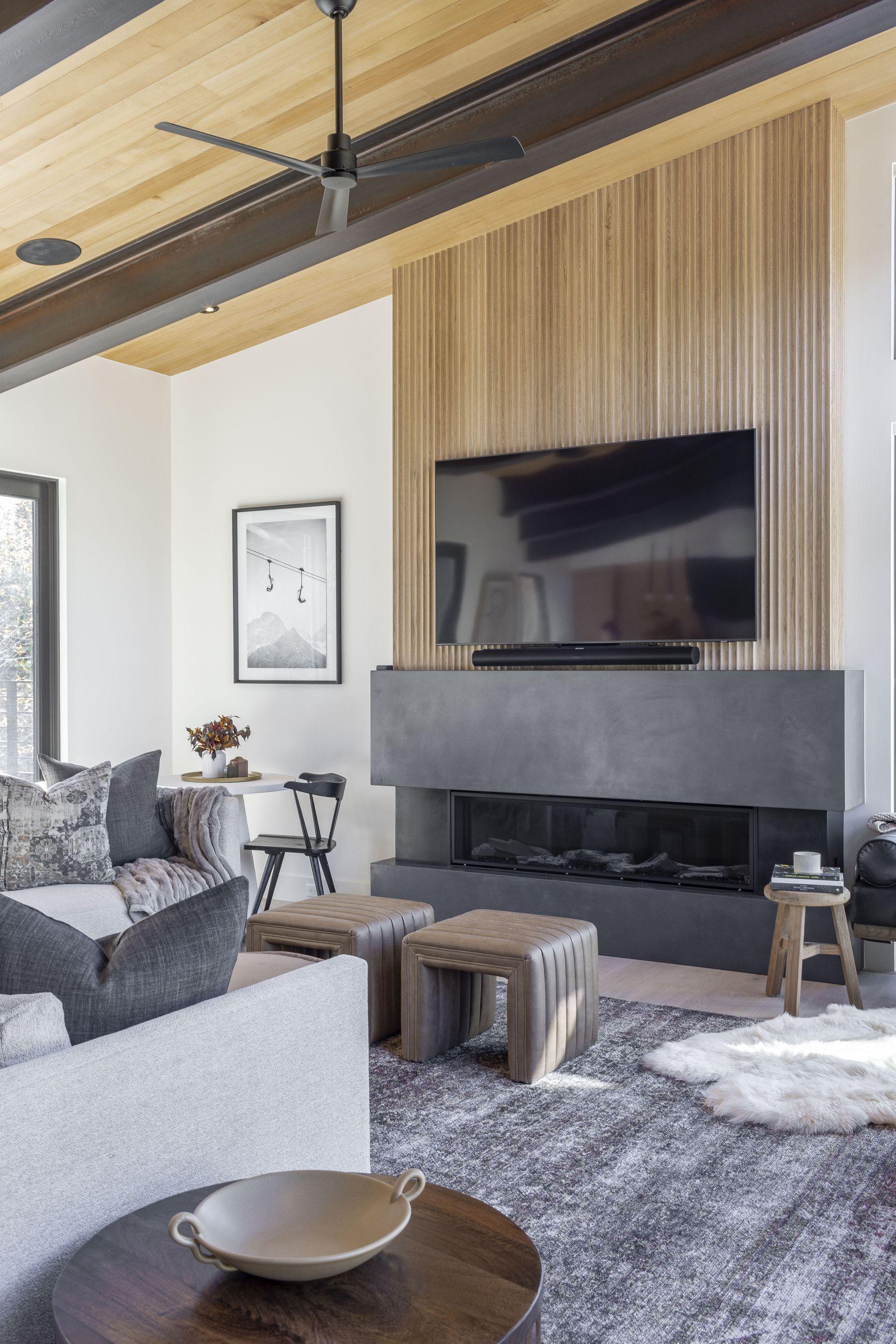 Living room with a linear fireplace beneath a timber ceiling