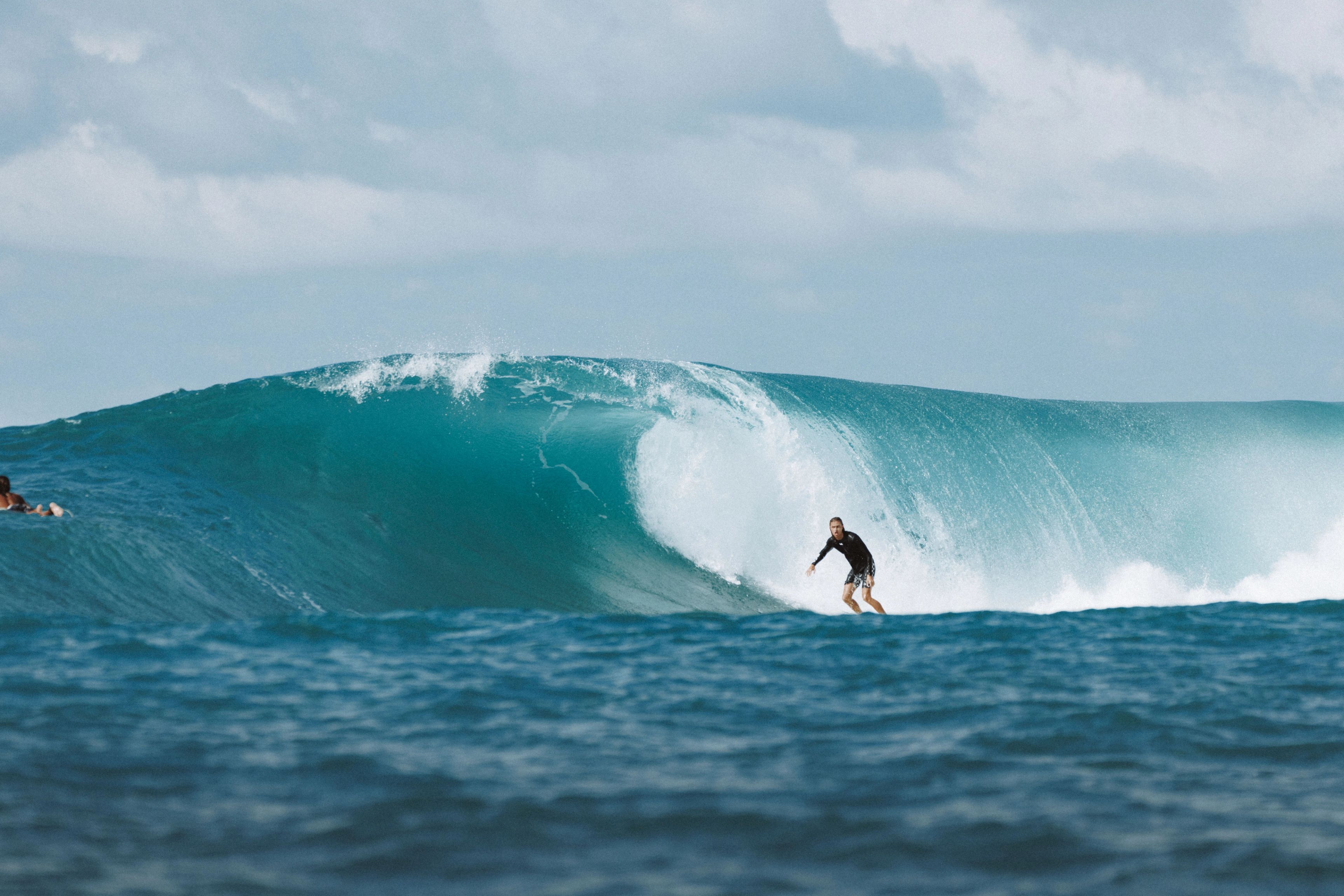 A surfer riding along the face of a breaking wave.