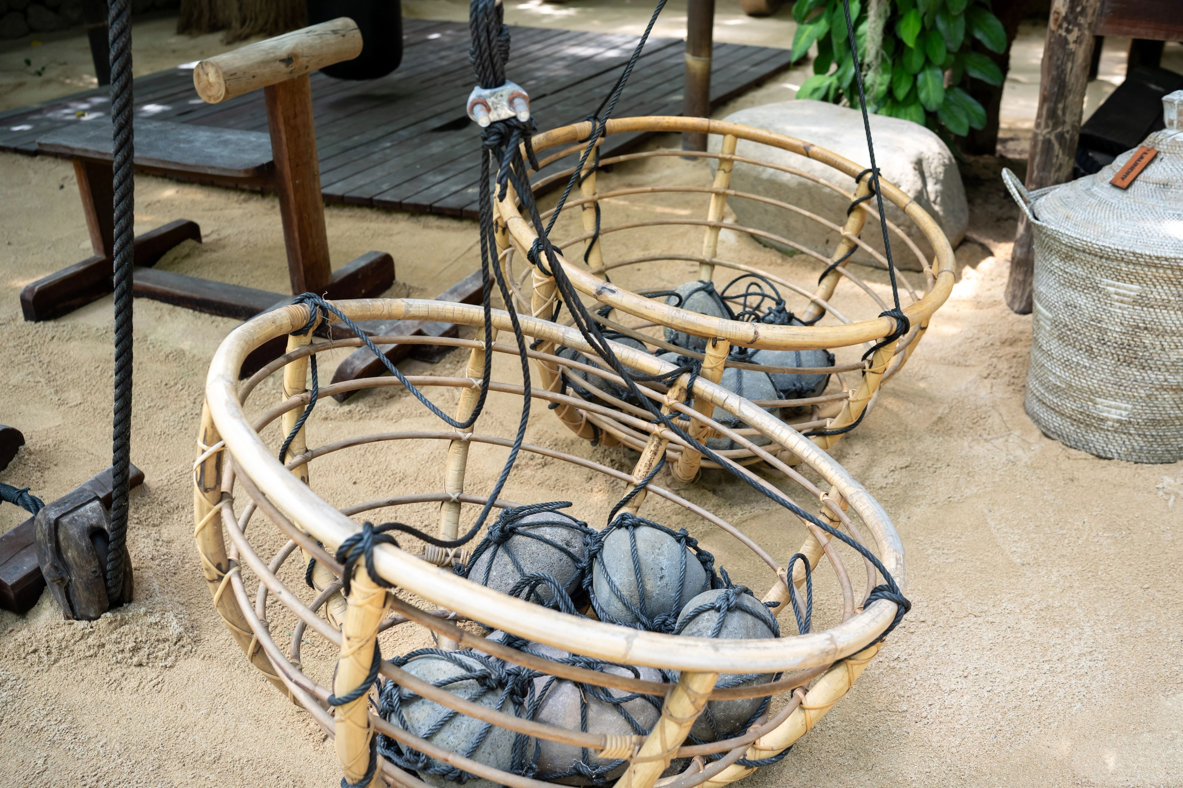 Rattan baskets loaded with netted river stones, used in place of cast weights.