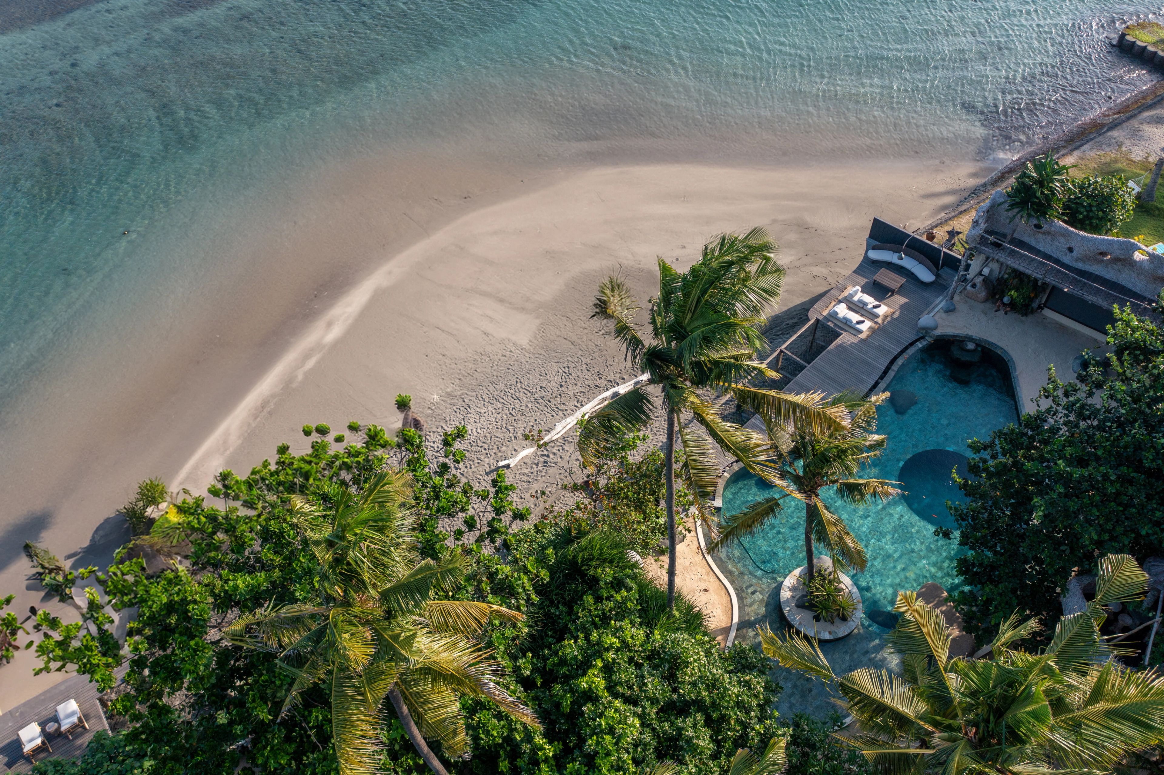 A wooden walkway through the trees down to the estate’s beach and the sea beyond