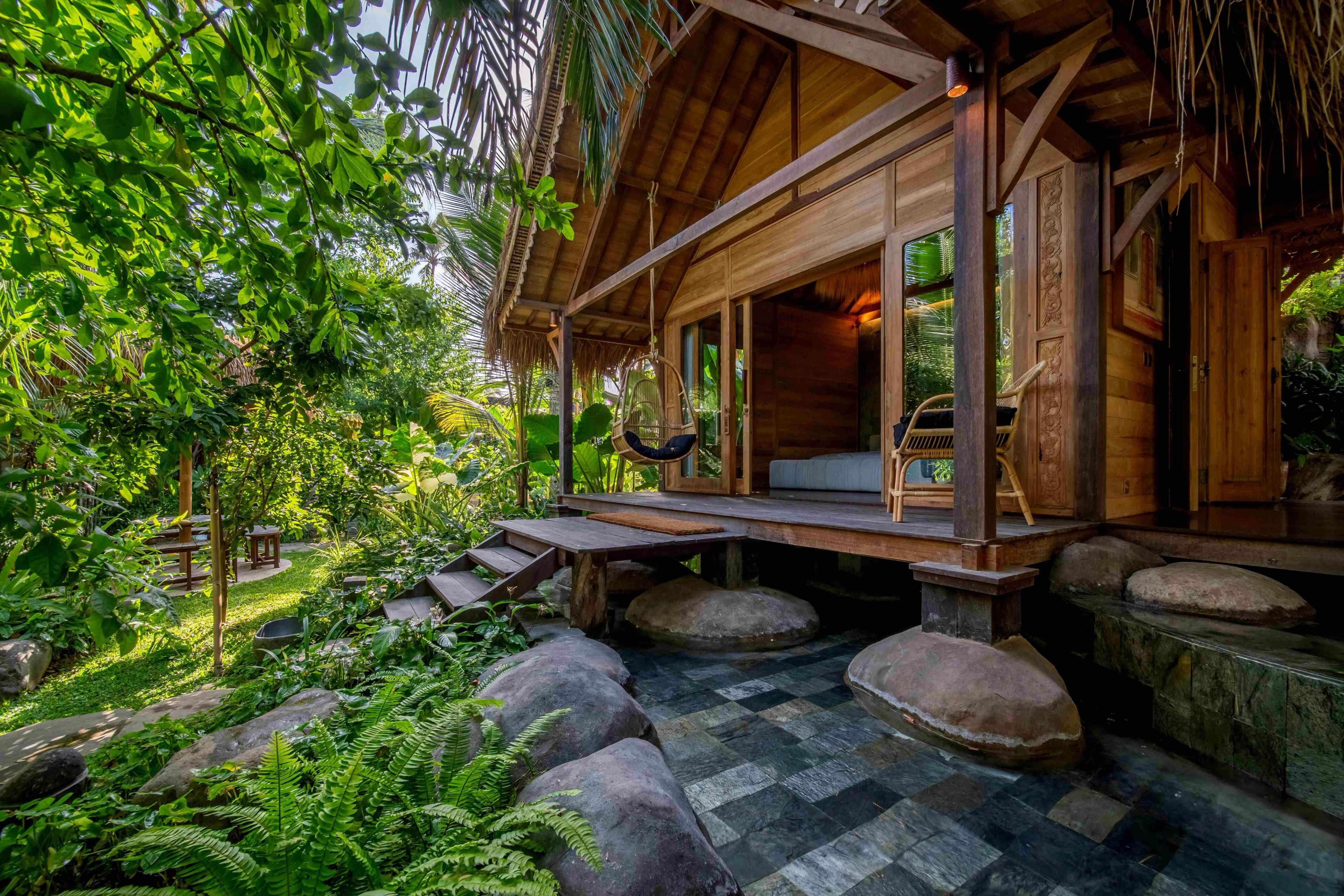 The timber villa seen across the stepping stones and boulders of the garden.