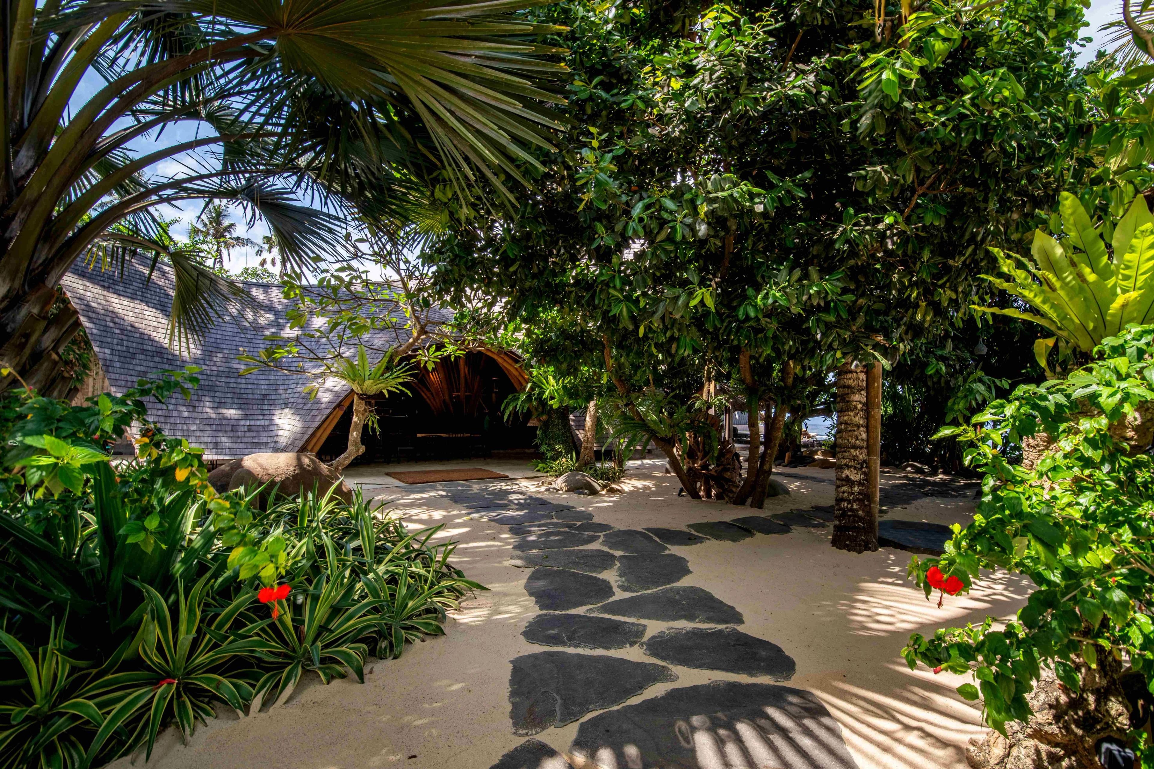 A flagstone path curving through the planting towards the restaurant's shingled roof.