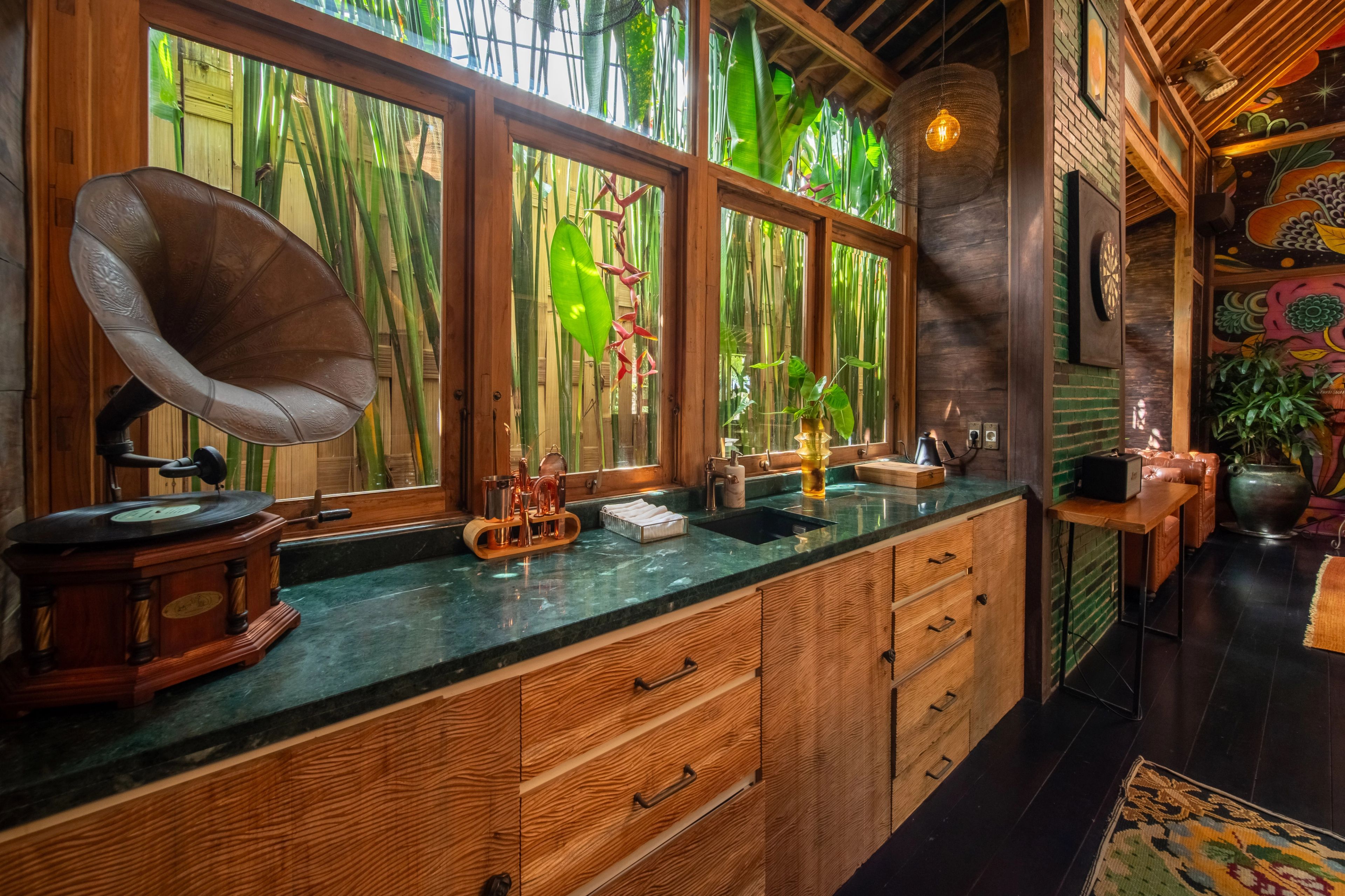 The long green stone counter with a gramophone at one end, windows onto the bamboo behind.