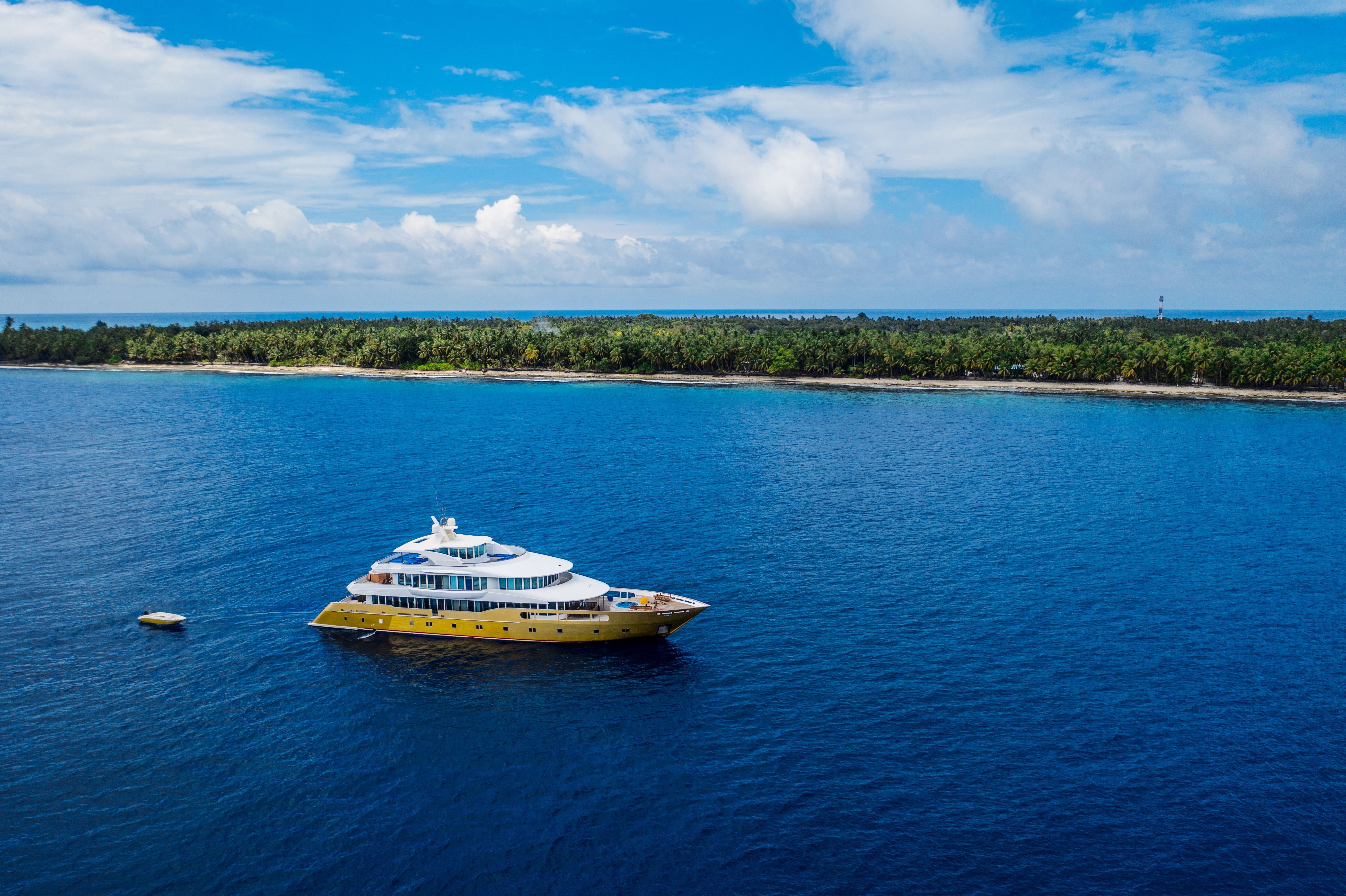 Aerial view of a Yacht boat anchored over a reef in clear water.