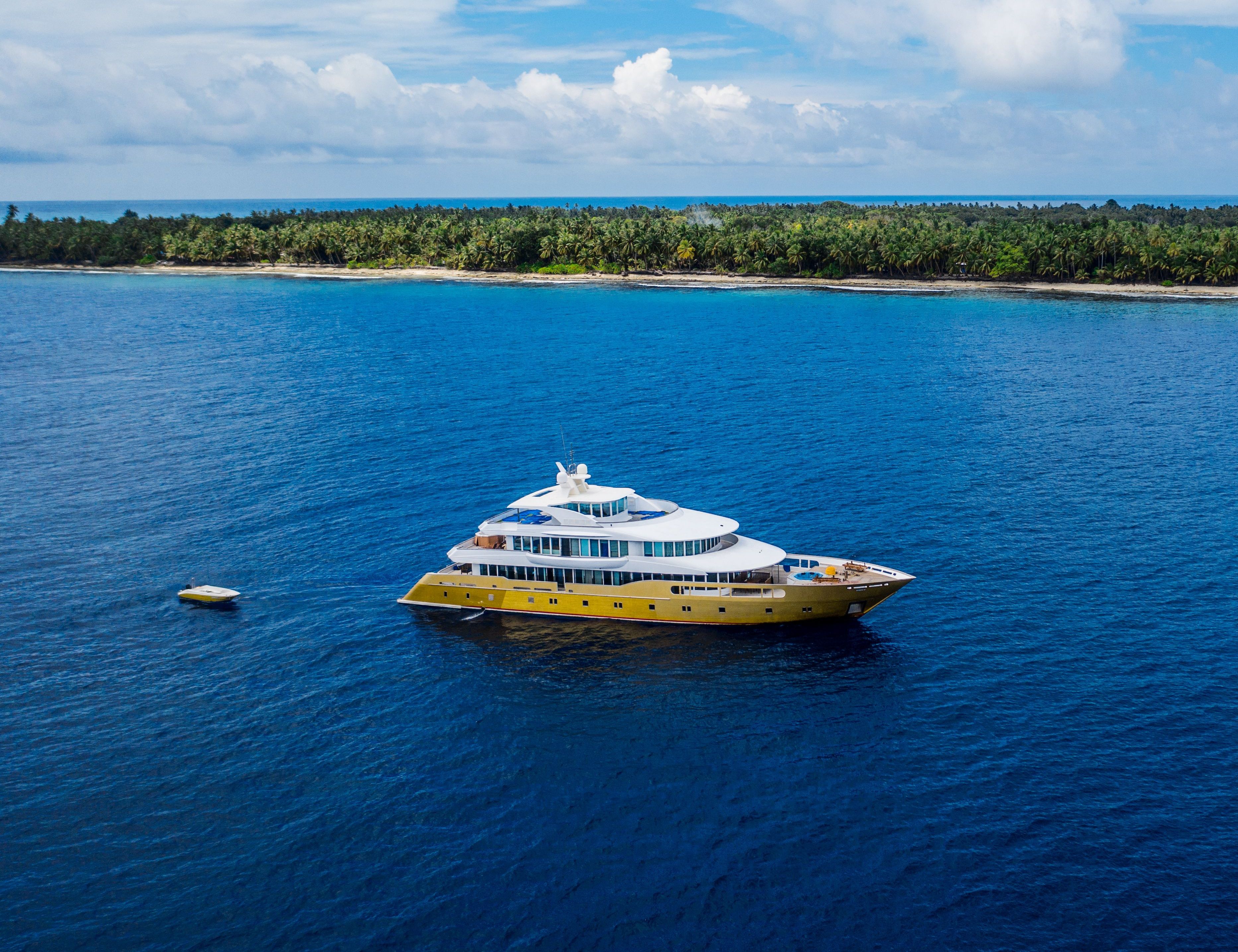 Aerial view of a Yacht boat anchored over a reef in clear water.