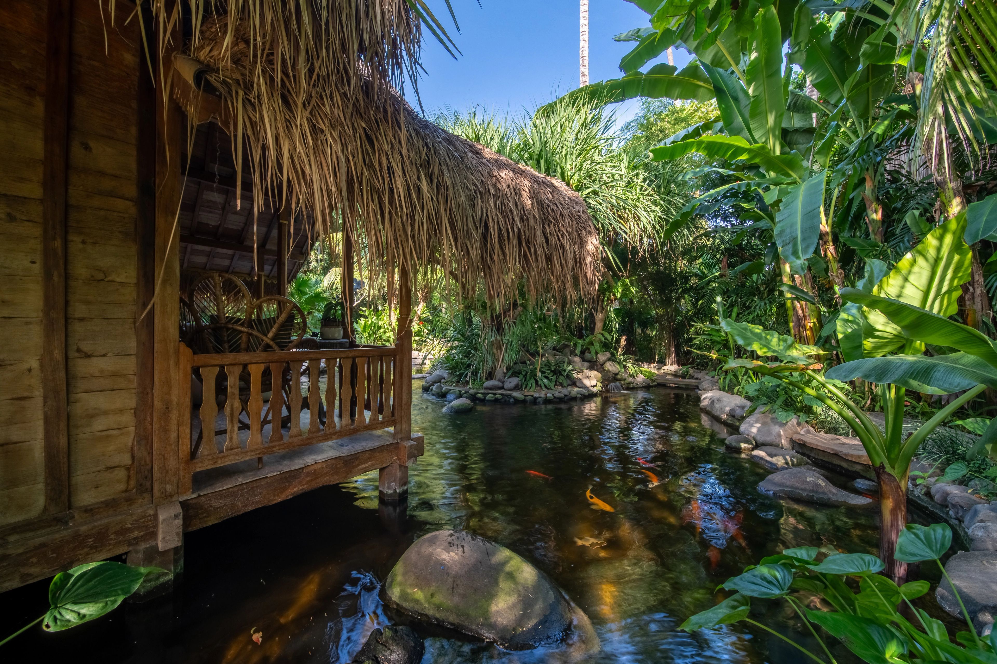 The timber veranda and its balustrade projecting out over the koi pond and its boulders.