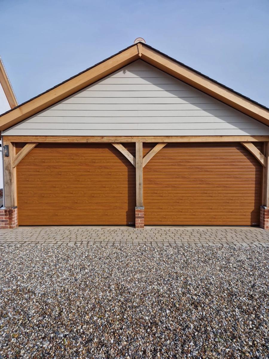 Brown roller garage doors in an oak-framed double garage