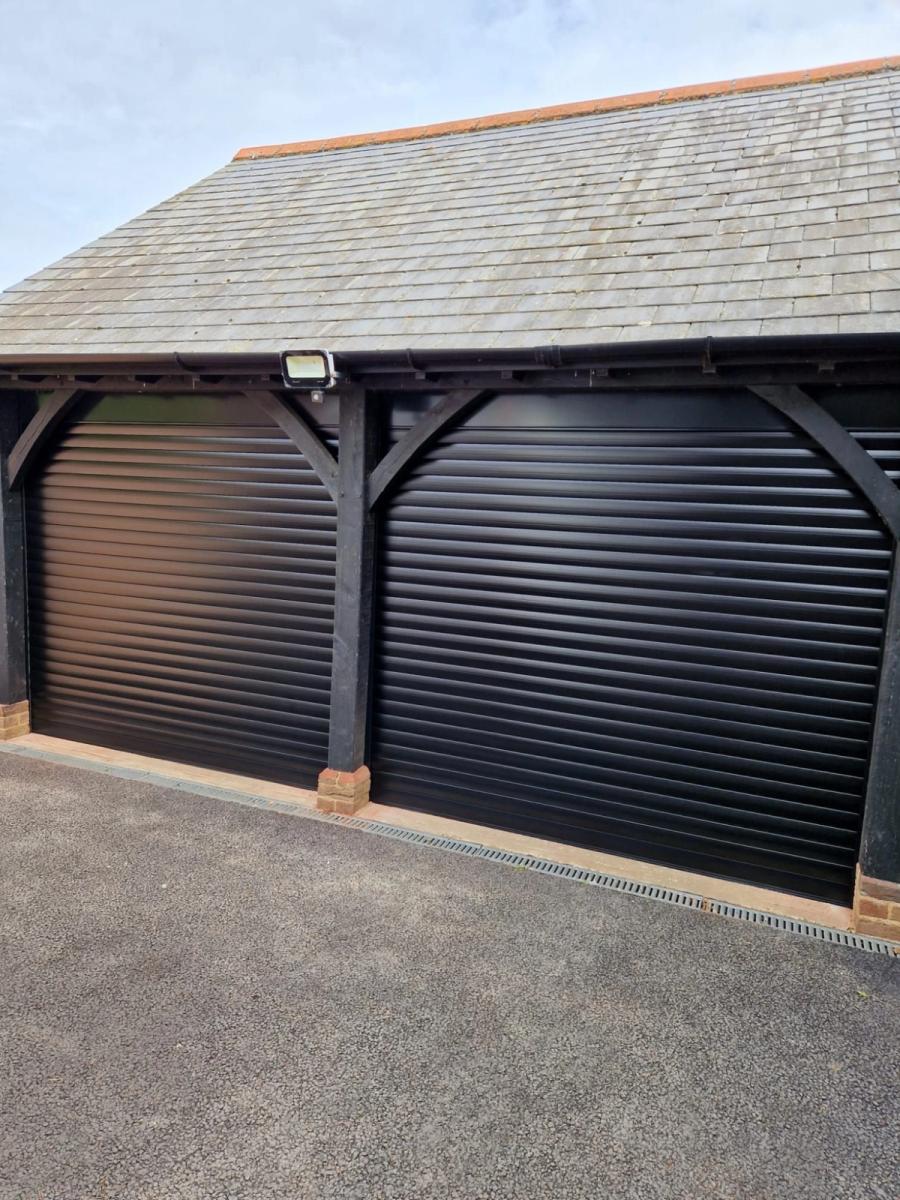 Anthracite grey roller doors in an oak-framed double garage