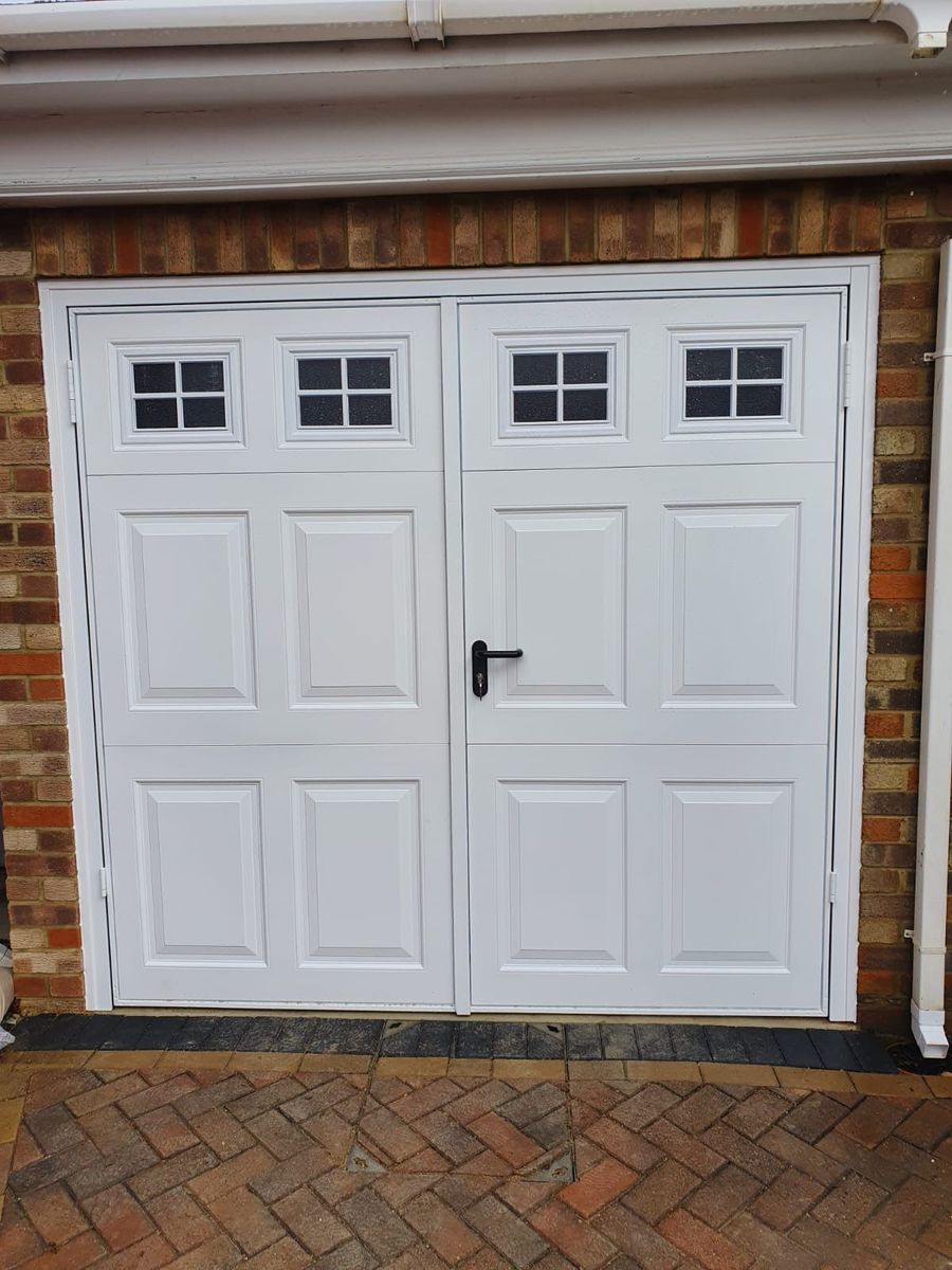 White side-hinged garage doors with window panels