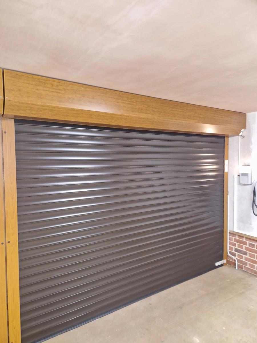 Black roller garage door in an oak-framed garage