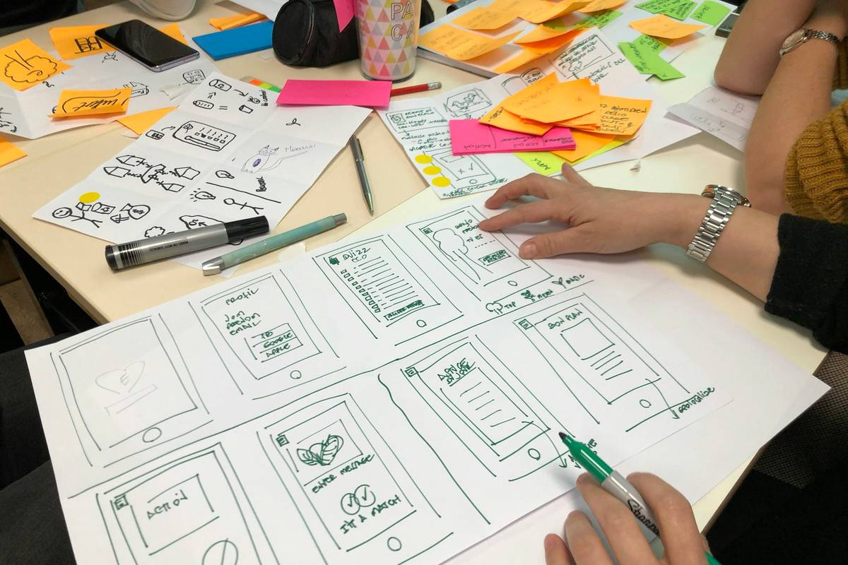 Founder sketching screens on paper while planning SaaS MVP development cost and scope