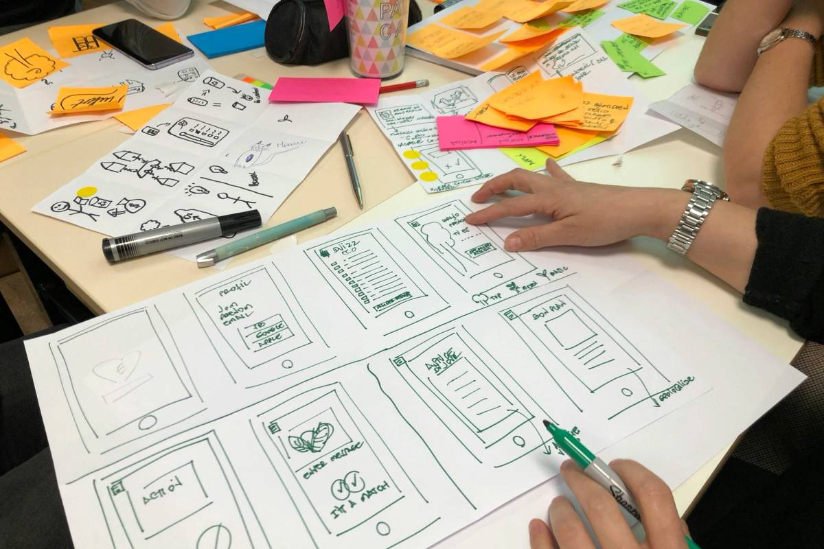 Founder sketching screens on paper while planning SaaS MVP development cost and scope