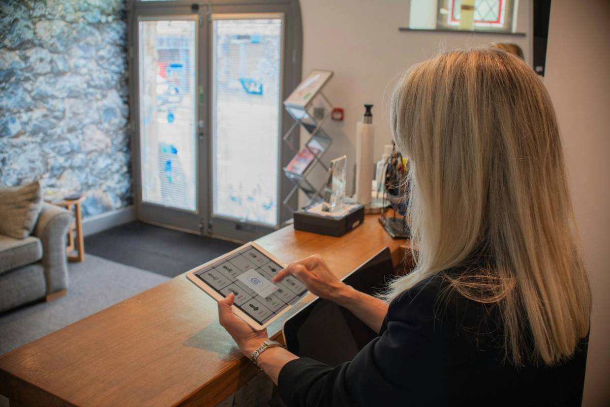Med spa front desk with a tablet showing a booking app, illustrating med spa app development cost