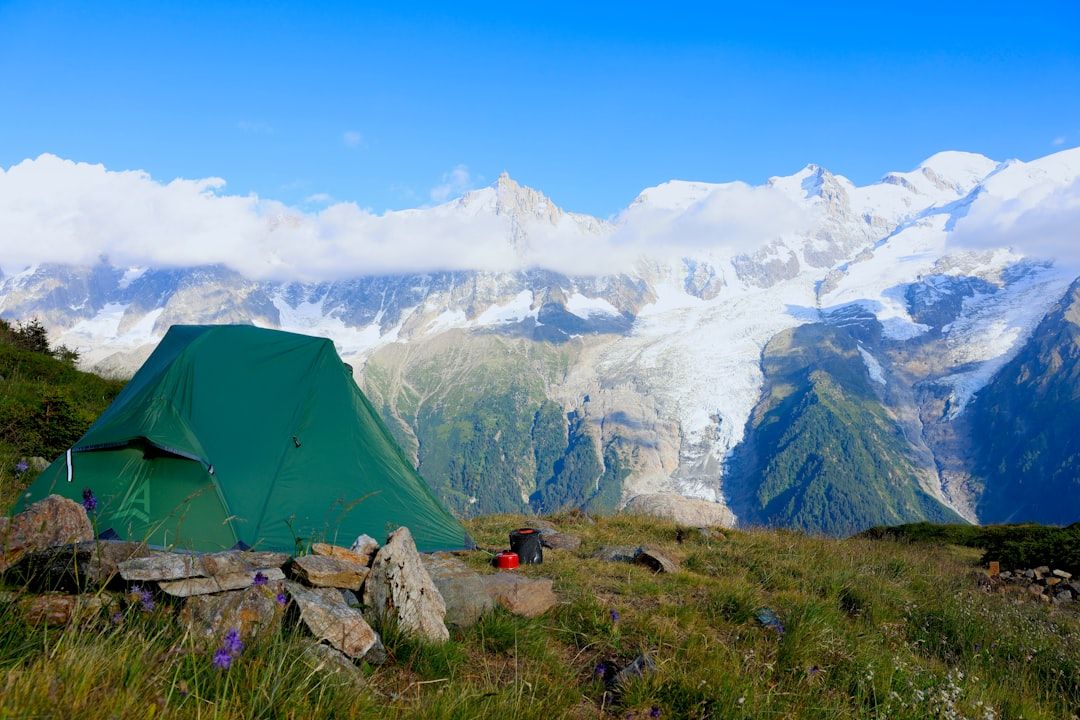 Tente de bivouac installée dans un paysage alpin au coucher du soleil
