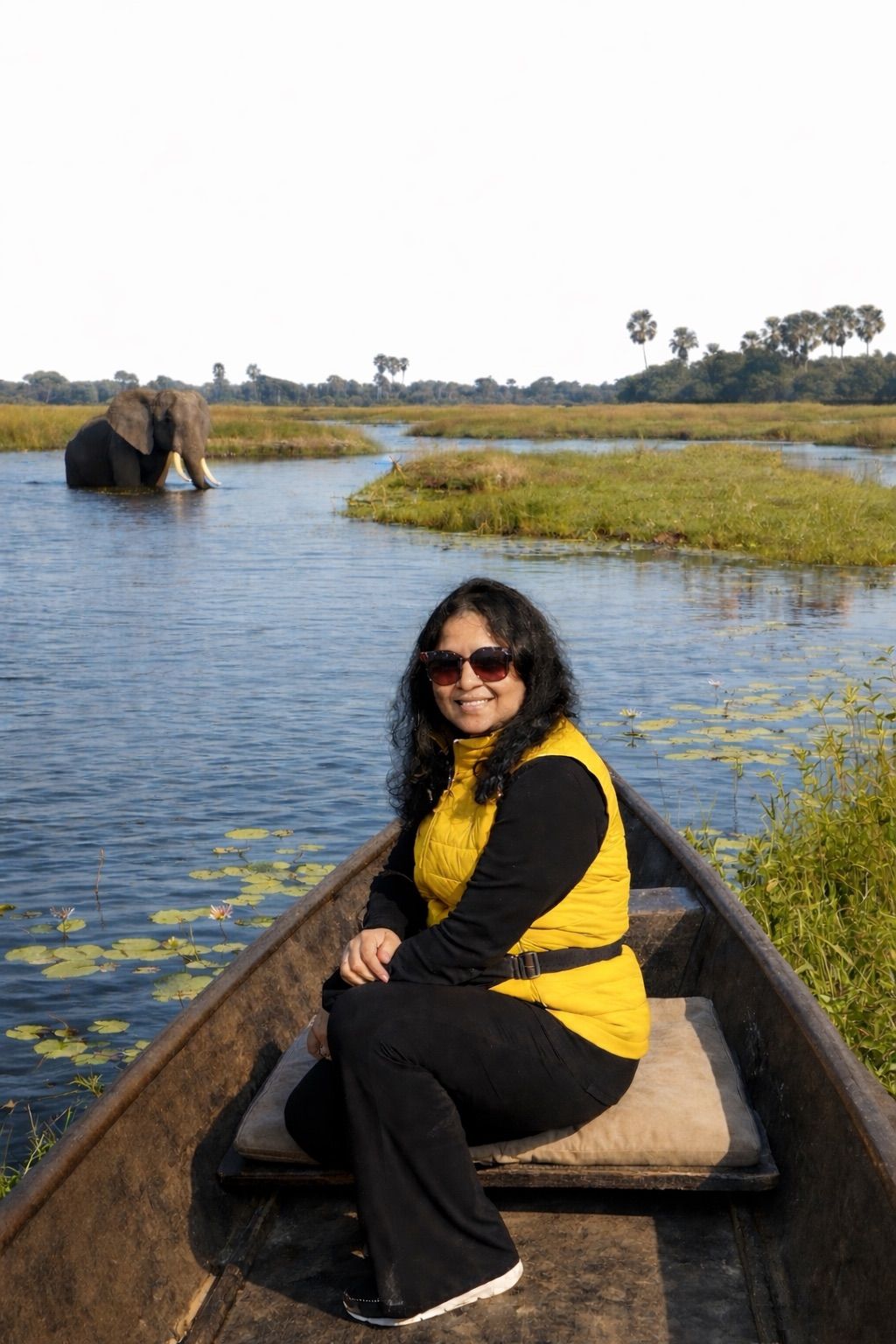 Hemakshi on a mokoro with an elephant in the distance — Okavango Delta