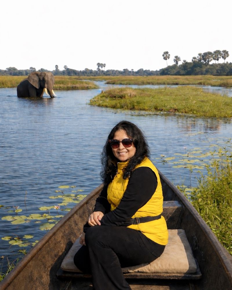 Hemakshi on a mokoro with an elephant in the distance — Okavango Delta