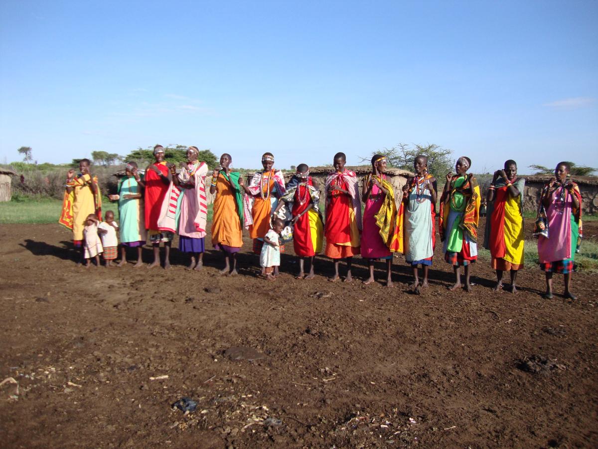 Maasai women in traditional dress, lined up in welcome