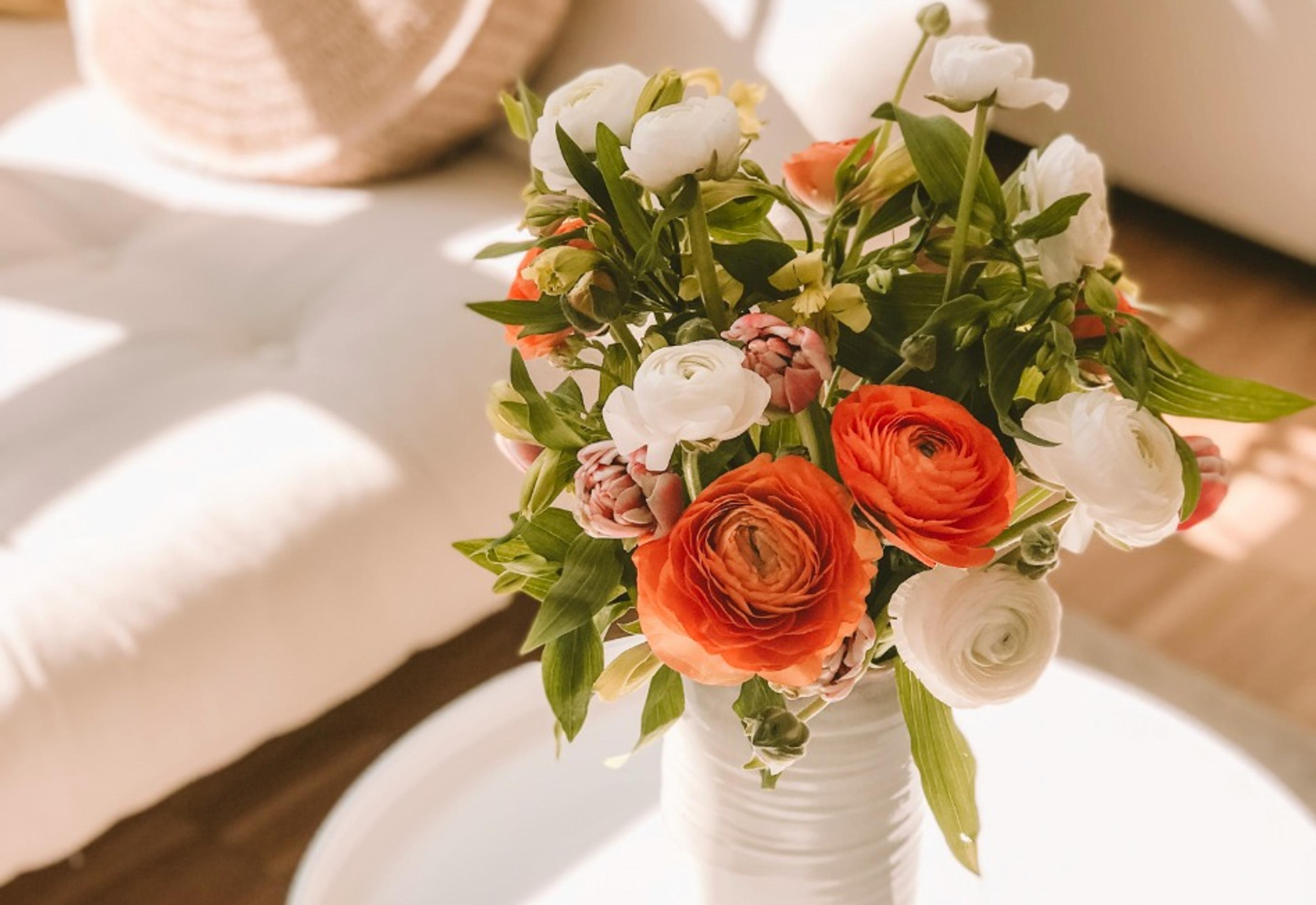 a vase filled with orange and white flowers is sitting on a table .