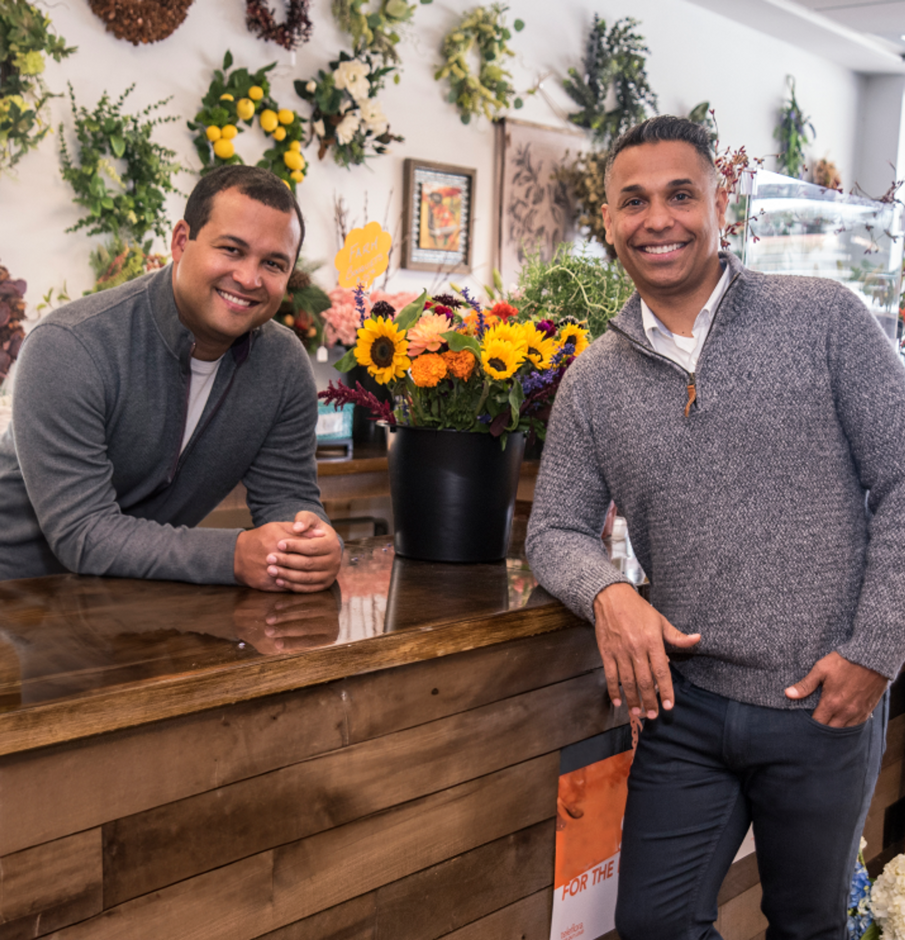 Co-ceo, Co-Founders Ken and Joe at a Flower Shop. Bright yellow sunflowers in background.